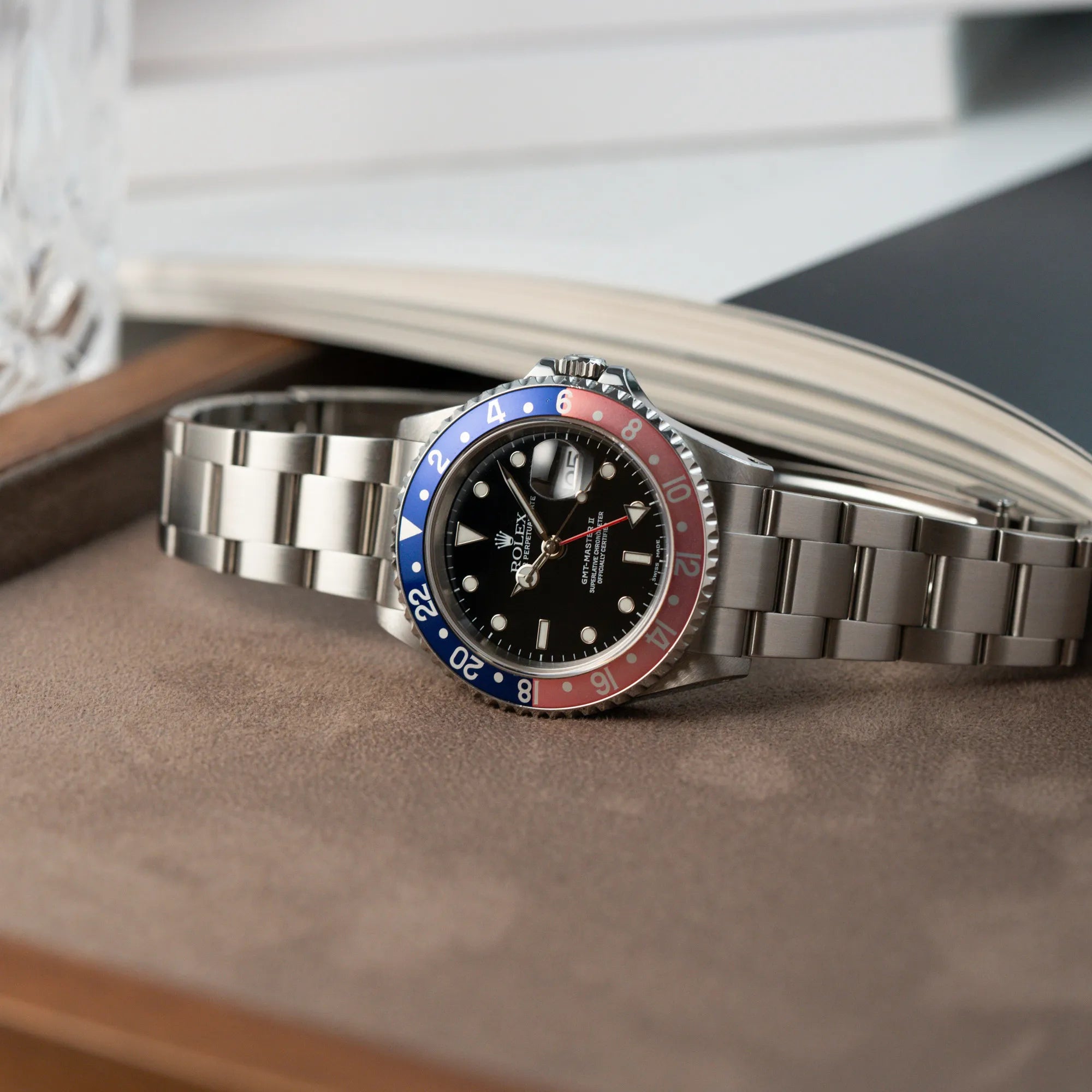 Produktfotografie Rolex GMT-Master 2 der Referenz 16710 mit der blau-roten Pepsi Lünette, die einen wunderschönen verblichenen Raspberry-Farbton