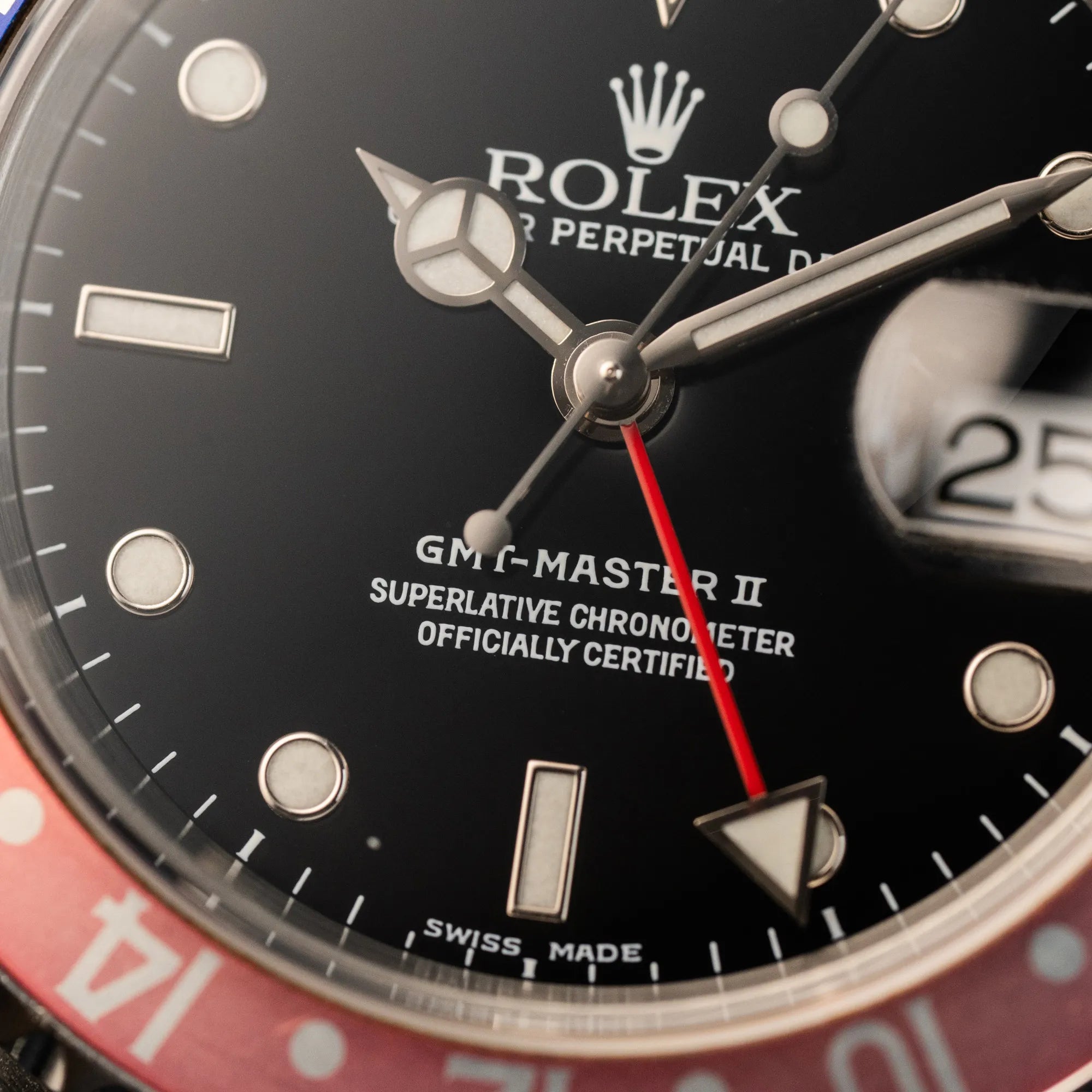Makroaufnahme des Zeigersatzes und Zifferblatts der Rolex GMT-Master 2 der Referenz 16710 mit der blau-roten Pepsi Lünette, die einen wunderschönen verblichenen Raspberry-Farbton