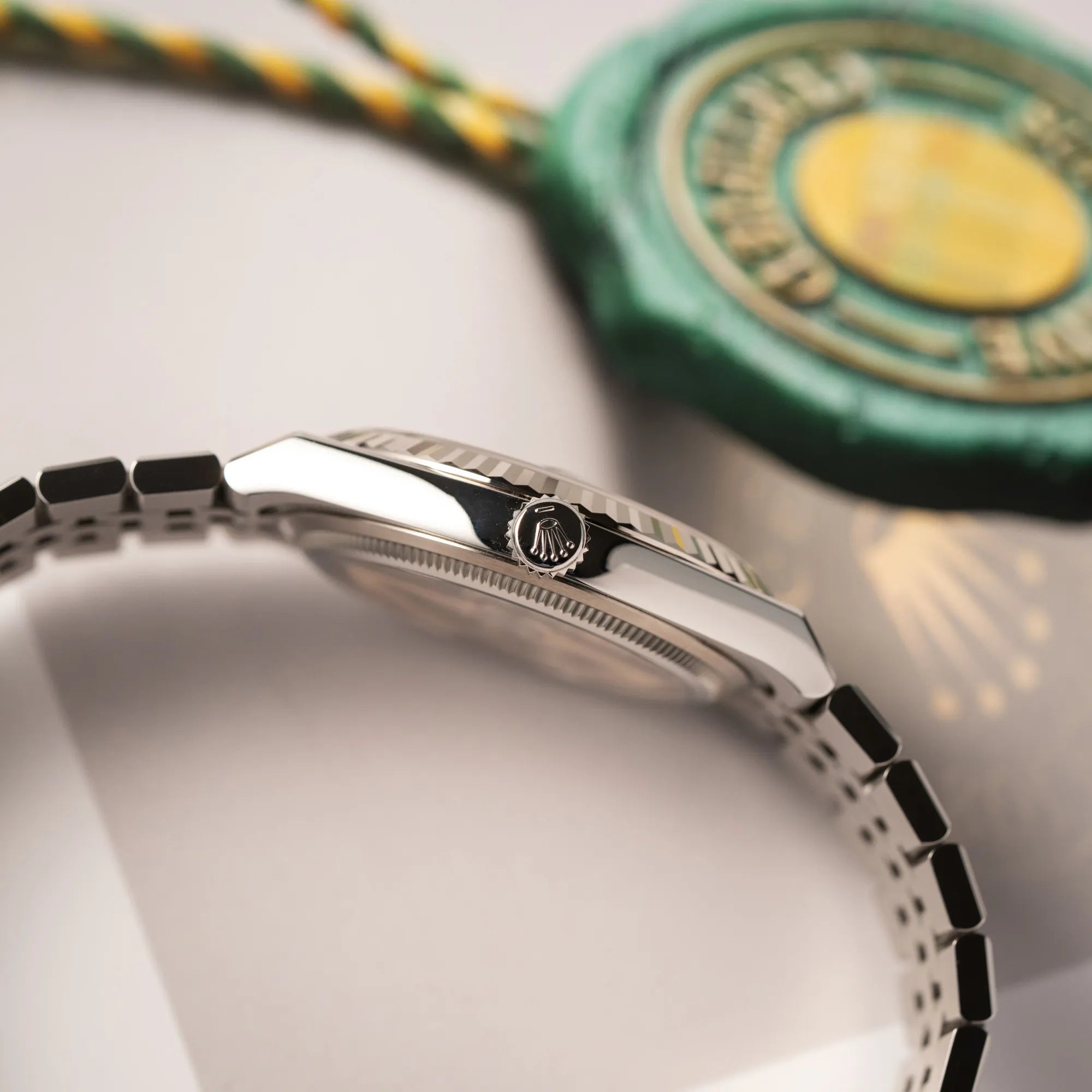 Seitliche Gehäuseflanke mit Blick auf die Aufzugskrone der Rolex Land-Dweller 40 der Referenz 127334 im neuwertigen Zustand mit dem weißen Zifferblatt in Waben-Struktur am neuen Flat-Jubilee-Armband