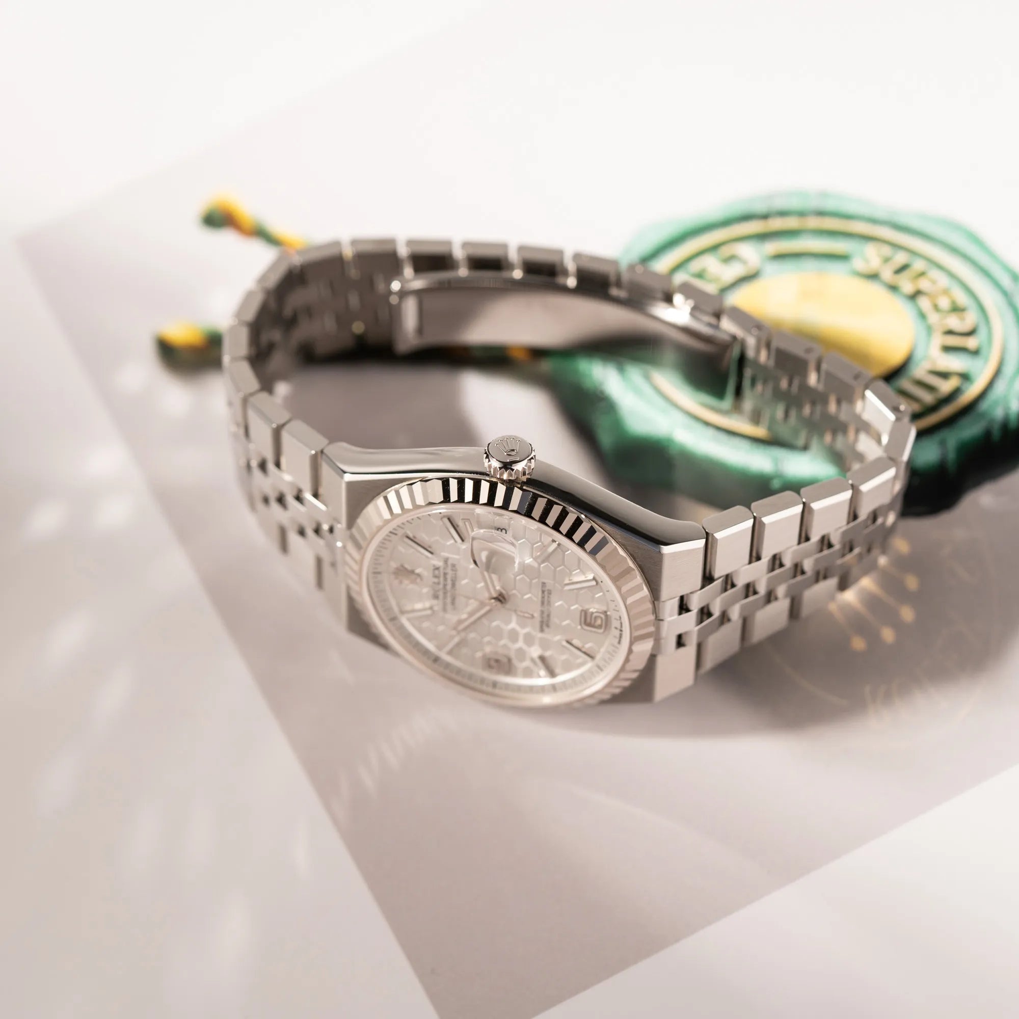Seitliche Gehäuseflanke der Rolex Land-Dweller 40 der Referenz 127334 im neuwertigen Zustand mit dem weißen Zifferblatt in Waben-Struktur am neuen Flat-Jubilee-Armband