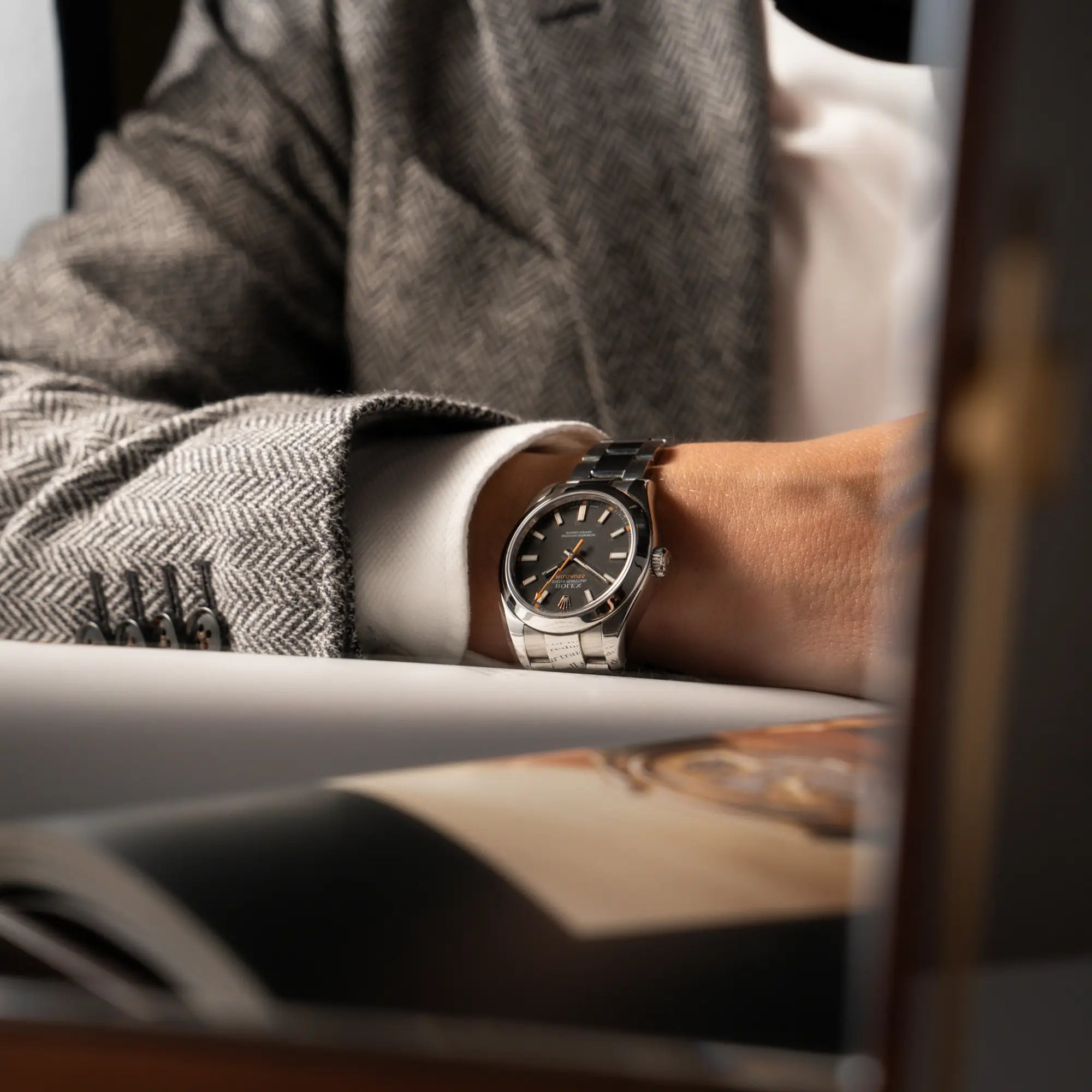 Mann trägt die Rolex Milgauss der Referenz 116400 mit schwarzem Zifferblatt und orangen Akzenten an seine Handgelenk