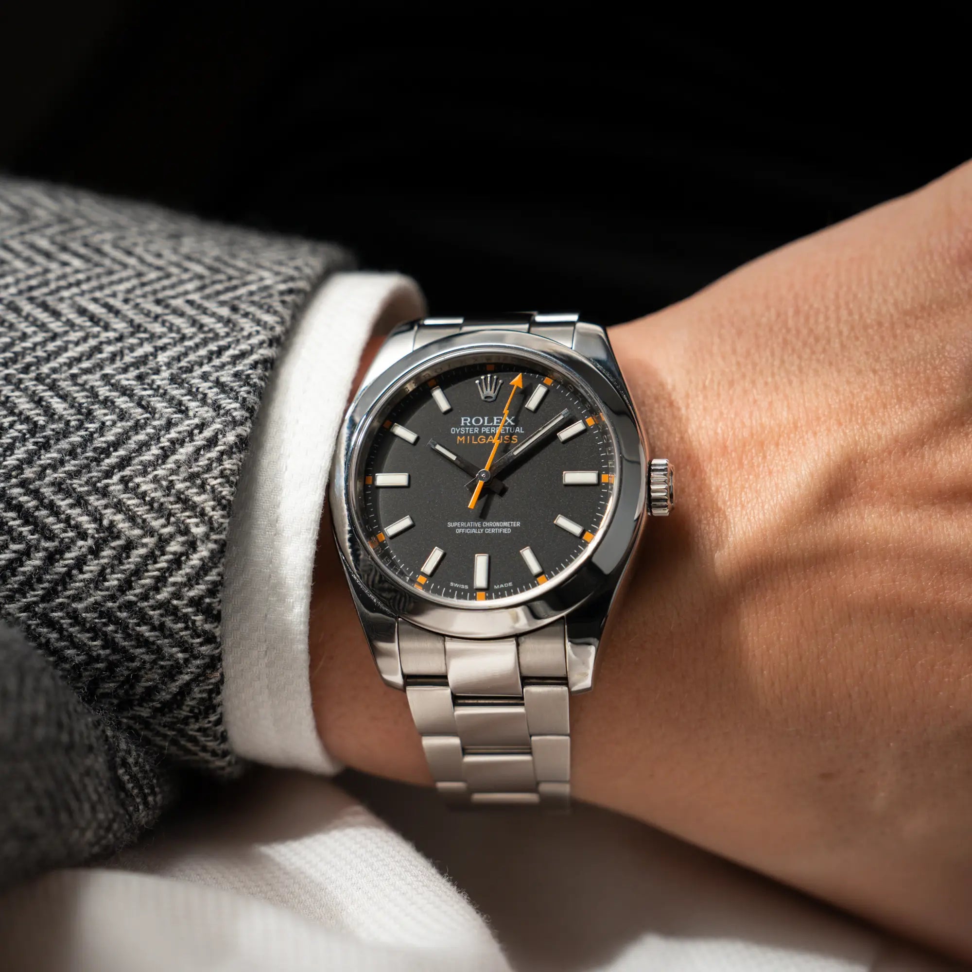 Mann trägt die Rolex Milgauss der Referenz 116400 mit schwarzem Zifferblatt und orangen Akzenten für einen Wristshot am Handgelenk