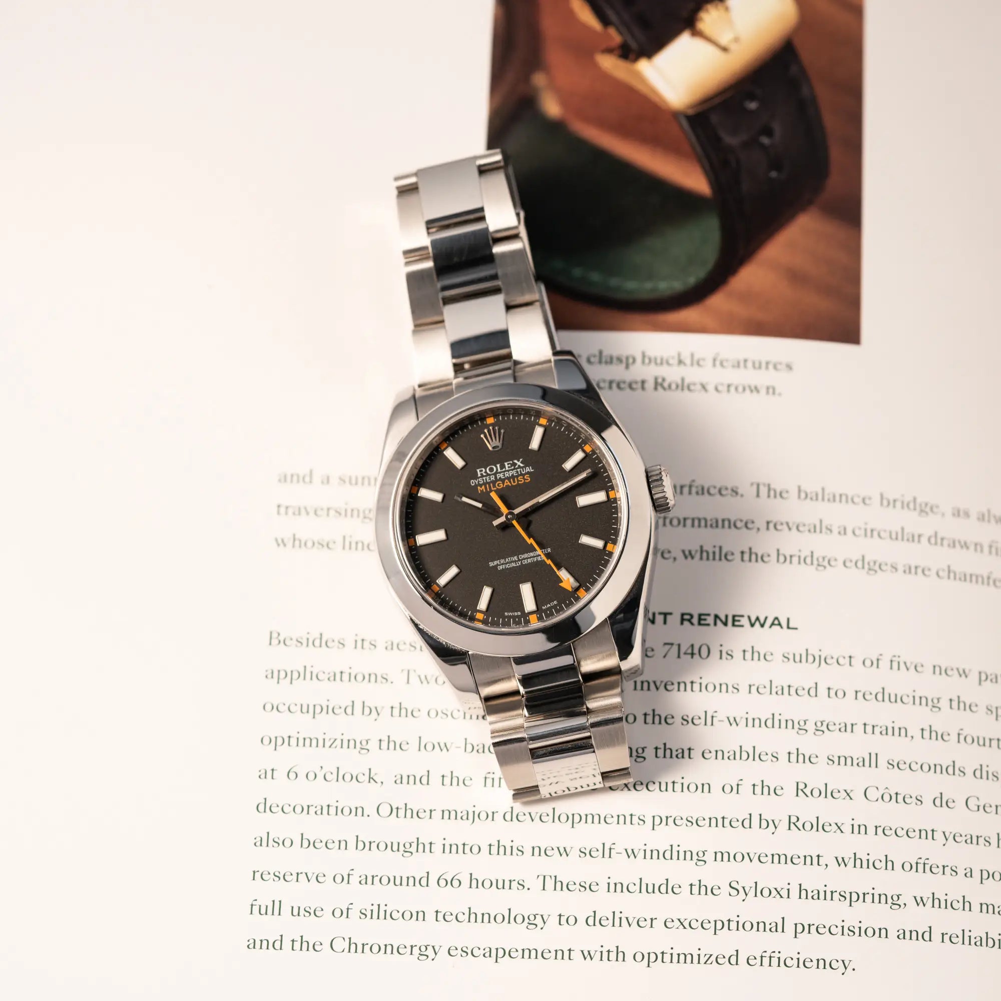 Produktfotografie der Rolex Milgauss der Referenz 116400 mit schwarzem Zifferblatt und orangen Akzenten