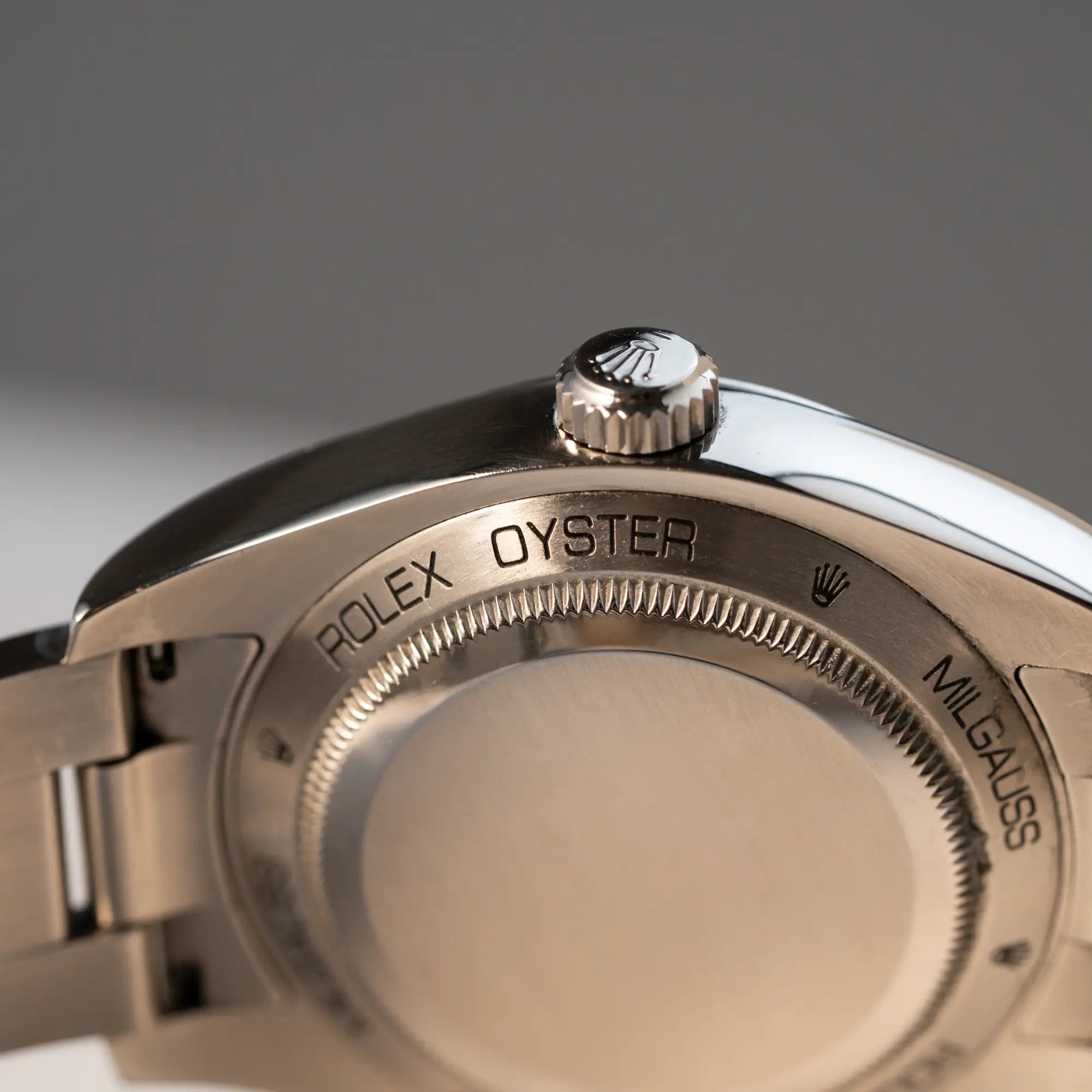 Produktfoto der Rolex Milgauss der Referenz 116400 mit schwarzem Zifferblatt und orangen Akzenten mit Fokus auf dem Gehäuseboden und der Krone