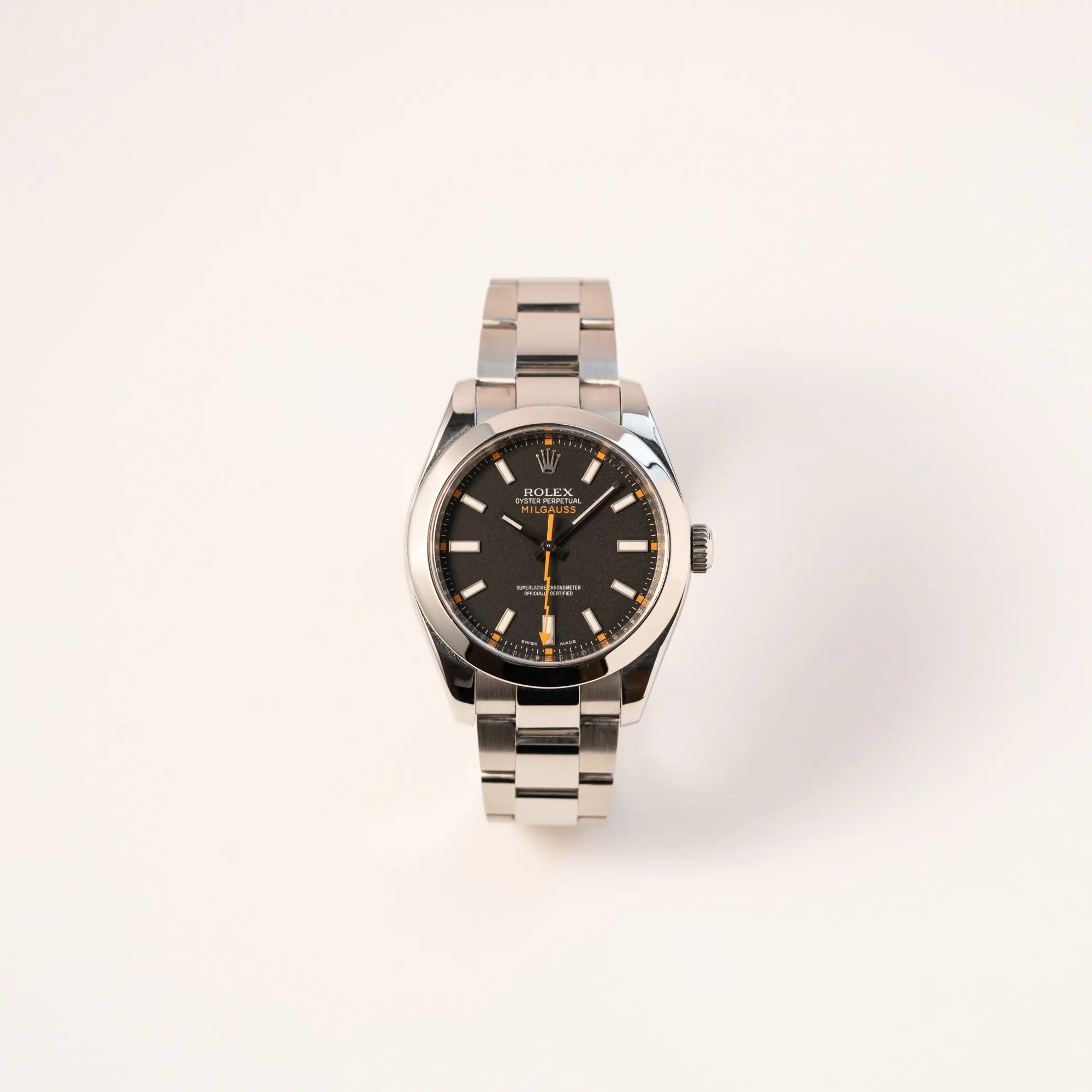 Frontale Ansicht der Rolex Milgauss der Referenz 116400 mit schwarzem Zifferblatt und orangen Akzenten