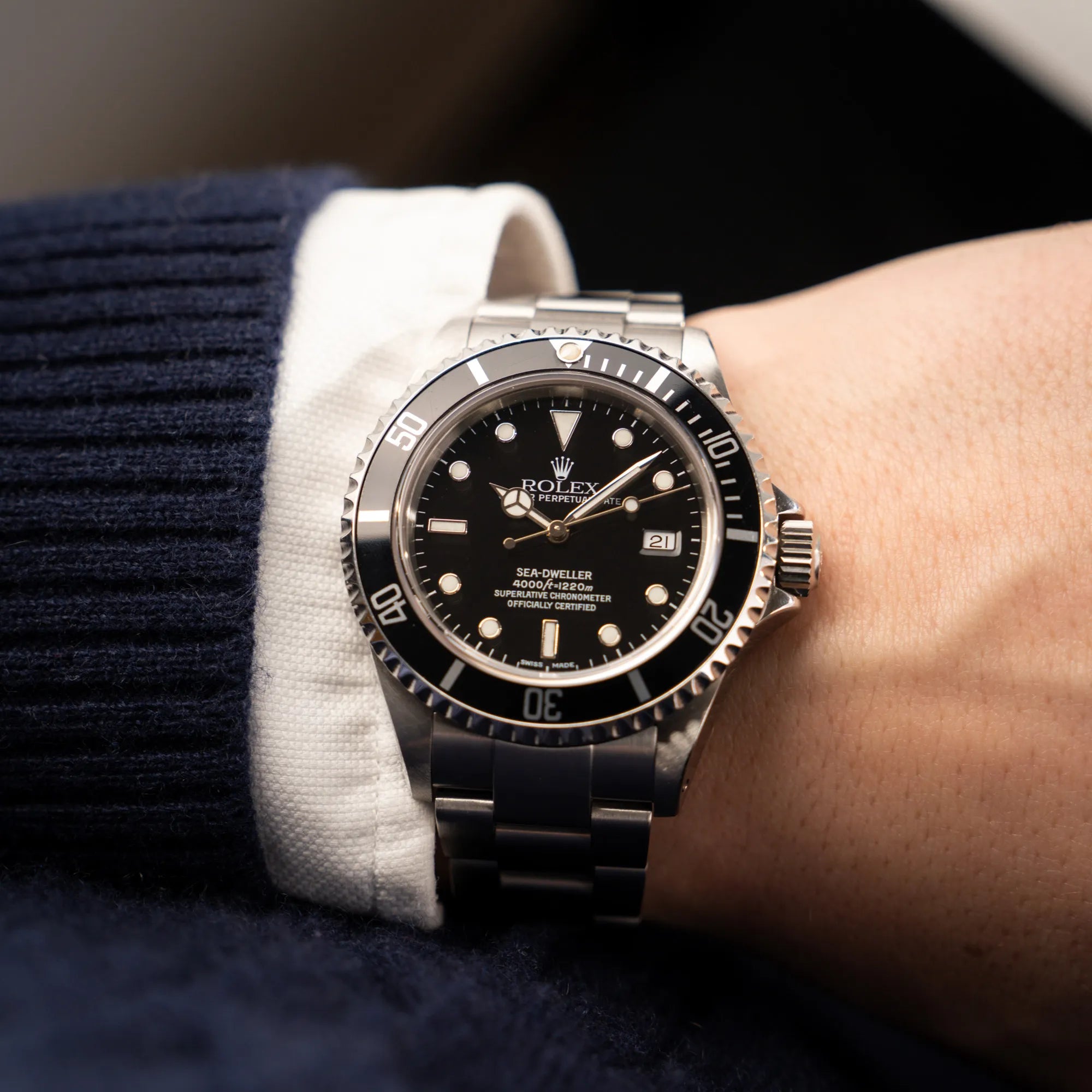 Mann trägt die Rolex Sea-Dweller 4000 der Referenz 16600 mit der klassischen schwarzen Aluminium-Lünette aus Dezember 2002 für einen Wristshot an seinem Handgelenk