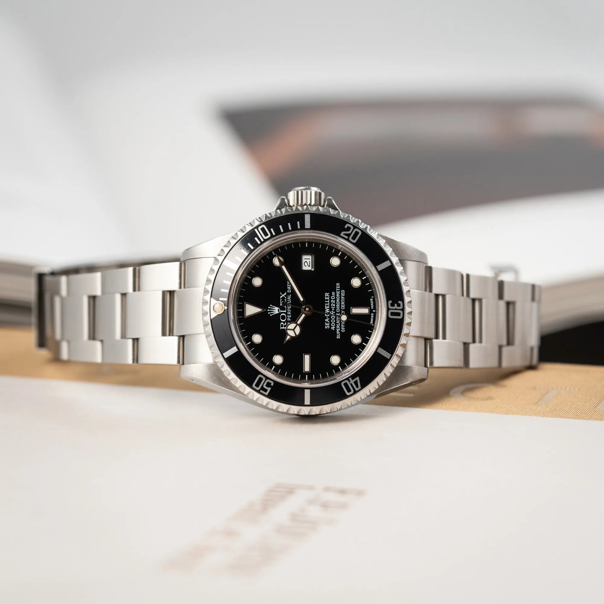 Rolex Sea-Dweller 4000 der Referenz 16600 mit der klassischen schwarzen Aluminium-Lünette aus Dezember 2002 liegt auf der seitlichen Gehäuseflanke