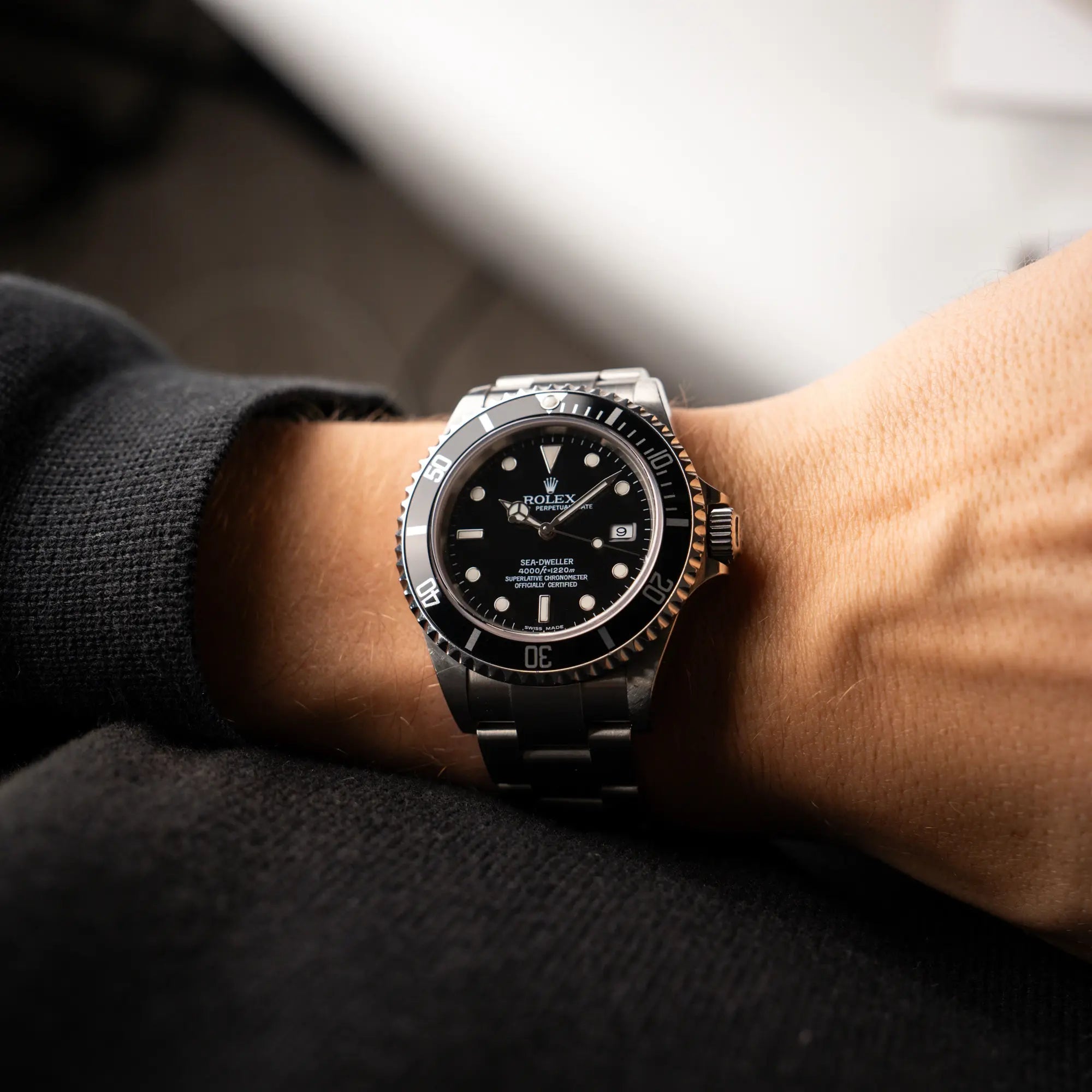 Mann trägt die Rolex Sea-Dweller 4000 in schwarz der Referenz 16600 mit typischen kleinem Datumsfenster