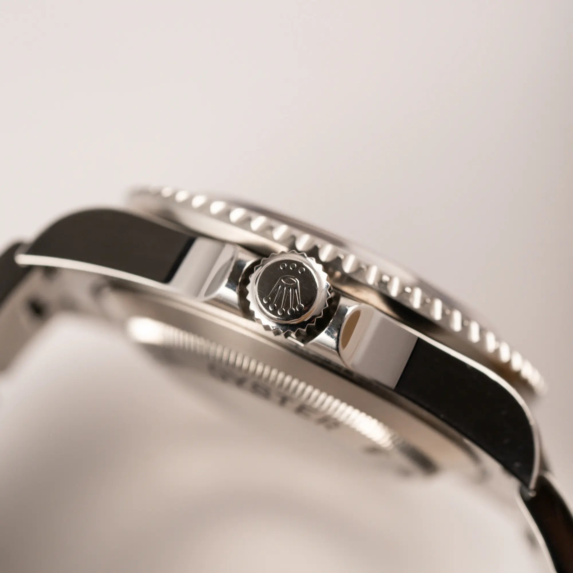 Detailaufnahme des seitlichen Gehäuses der Rolex Sea-Dweller 4000 in schwarz der Referenz 16600 mit typischen kleinem Datumsfenster mit Blick auf die Aufzugskrone