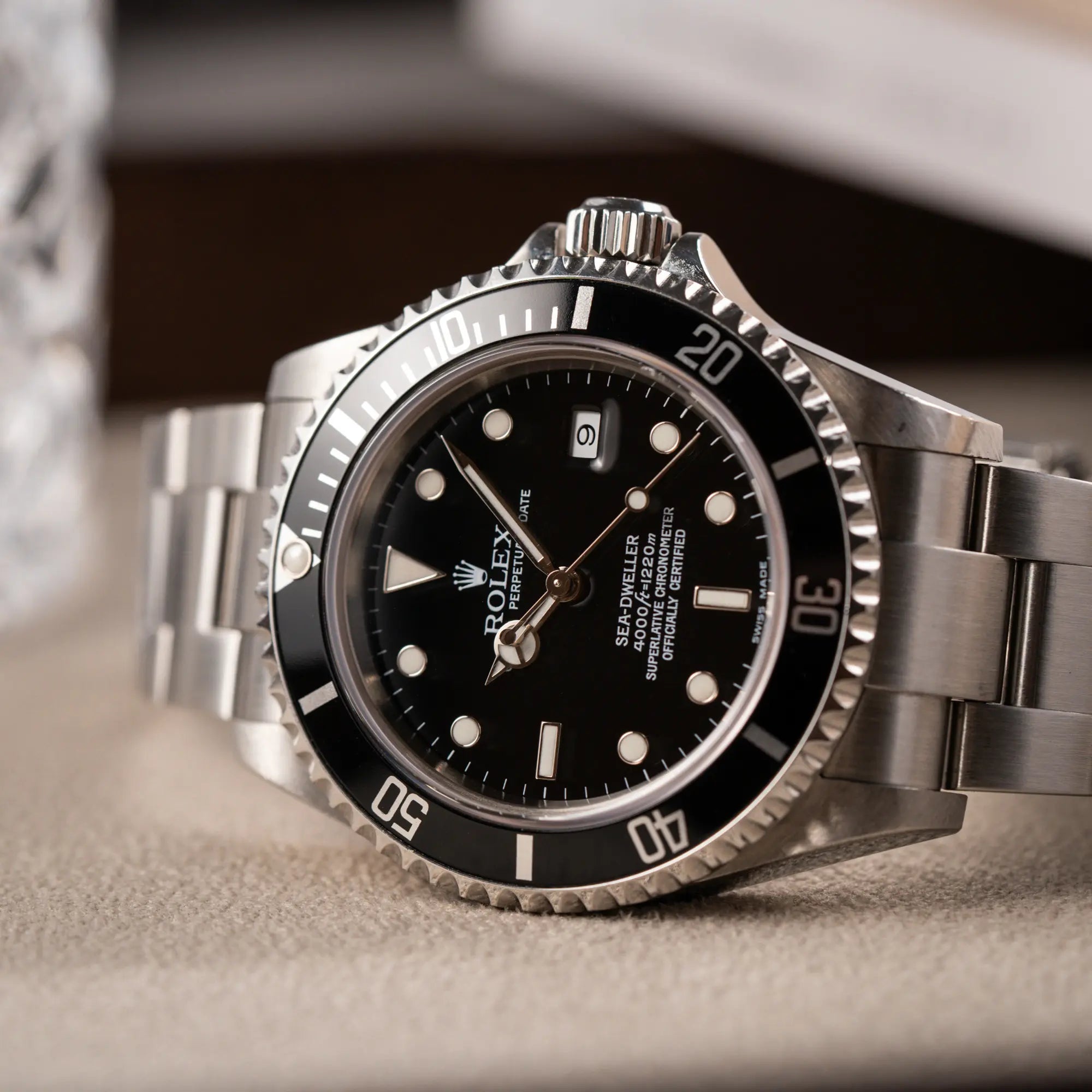 Produktfotografie der Rolex Sea-Dweller 4000 in schwarz der Referenz 16600 mit typischen kleinem Datumsfenster zeigt Zifferblatt und Lünetten-Einsatz