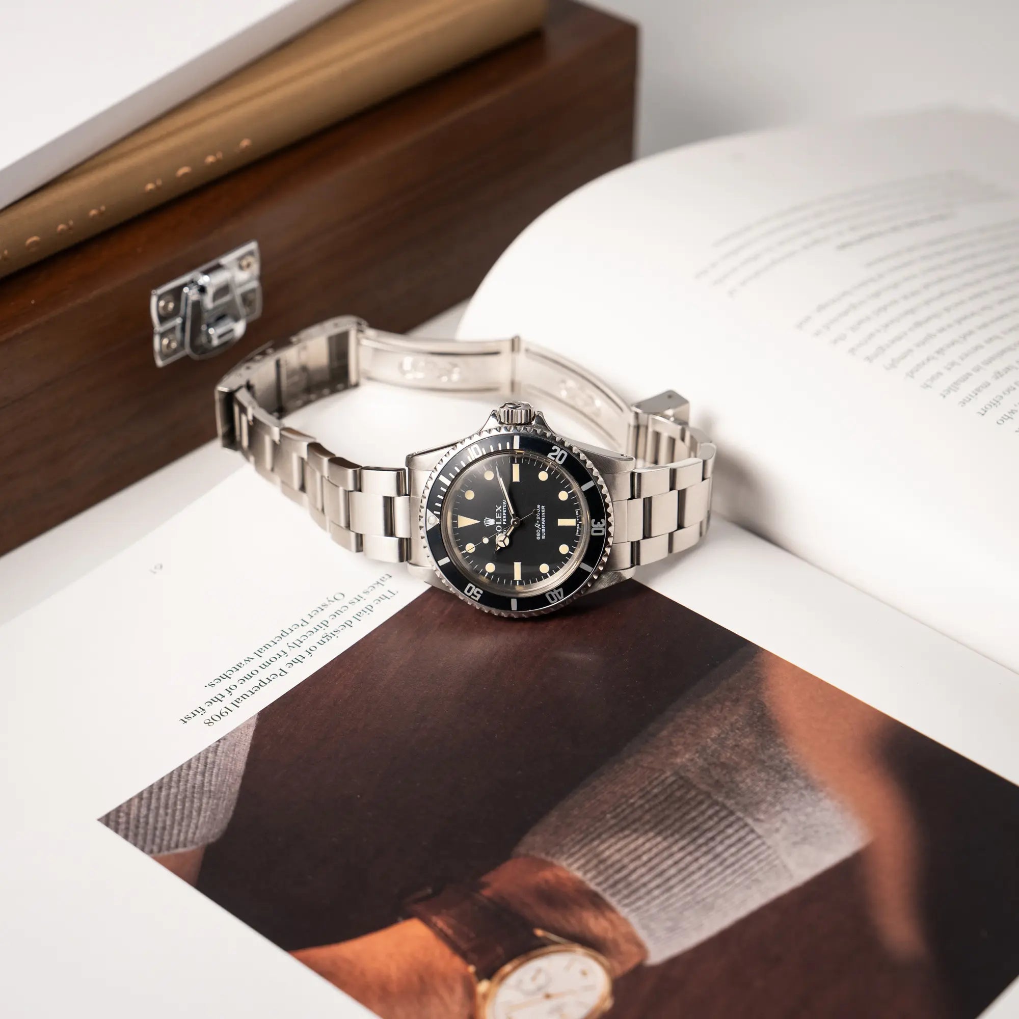 Rolex Submariner No Date MKII mit Serif Zifferblatt der Referenz 5513 aus 1970 mit gleichmäßiger Patina liegt mit geöffneter Faltschliesse auf der seitlichen Flanke des Uhrnegehäuses