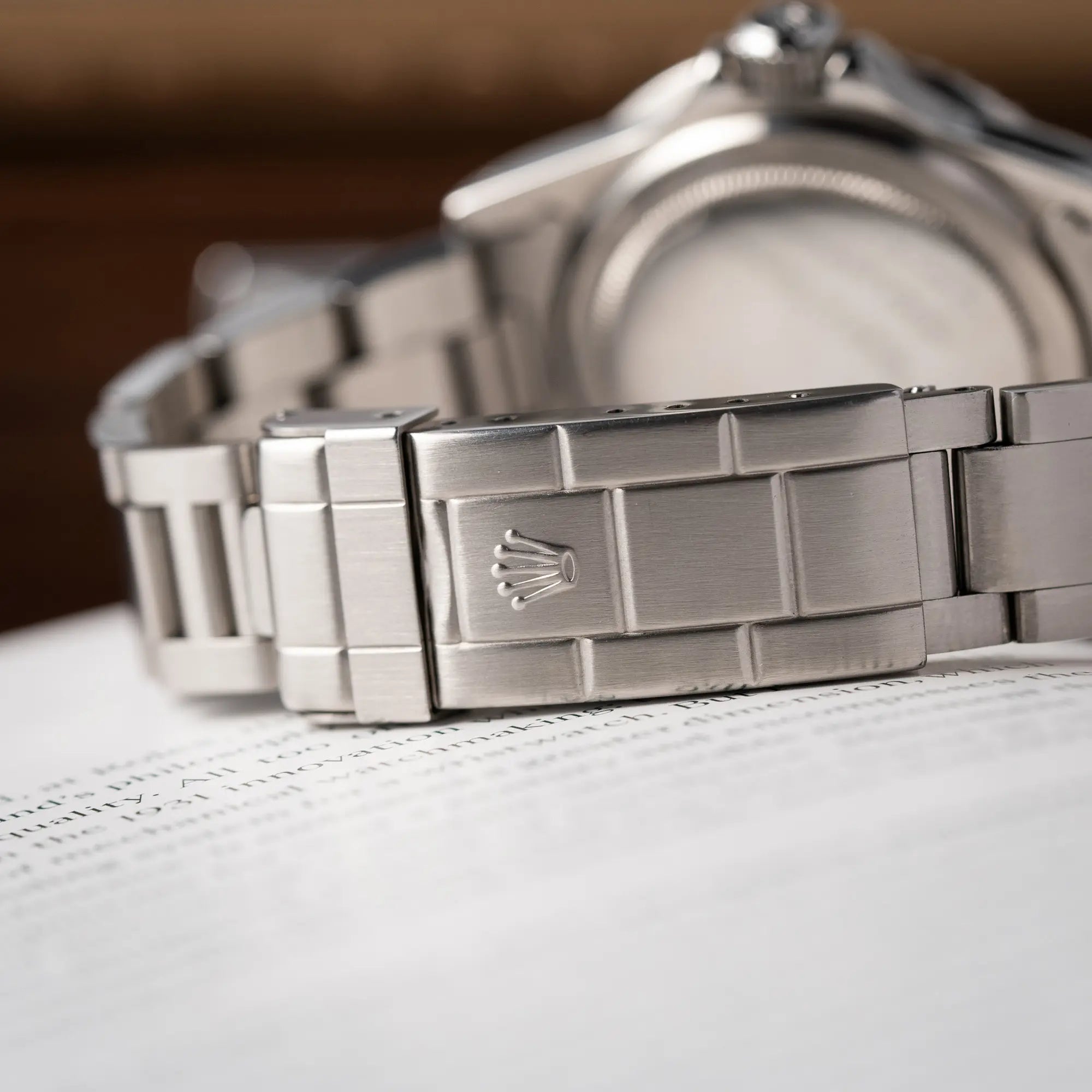 Nahaufnahme der Oyster-Stahl-Faltschliesse zeigt die Rolex krone bei der Rolex Submariner No Date MKII mit Serif Zifferblatt der Referenz 5513 aus 1970 mit gleichmäßiger Patina