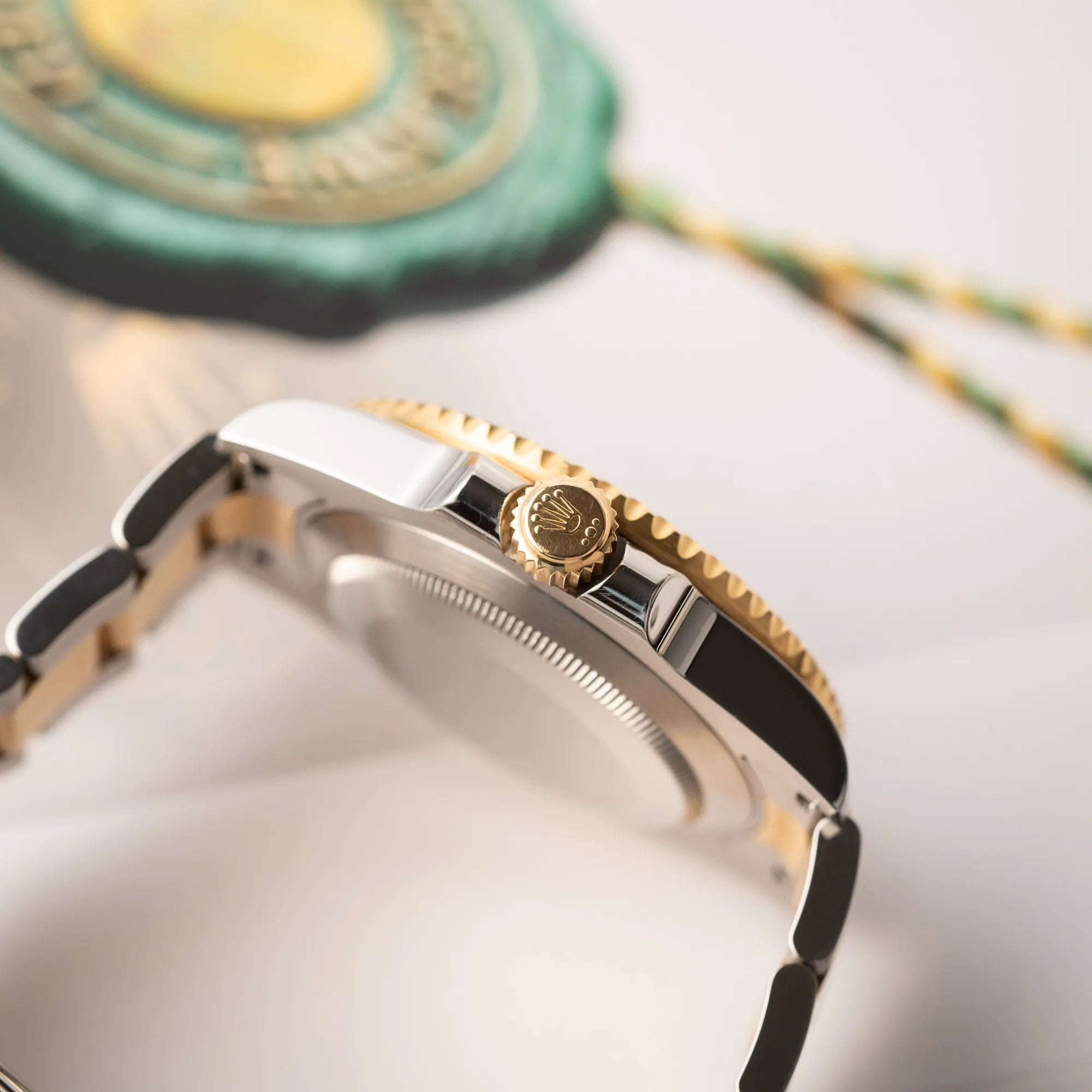 Seitliche Gehäuseflanke mit Blick auf die goldene Aufzugskrone von der Rolex Submariner Date der Referenz 116613LB in Stahl-Gold mit blauem Zifferblatt - auch mit Nickname Bluesy bennant - am passenden Oytser-Armband in Stahl-Gold