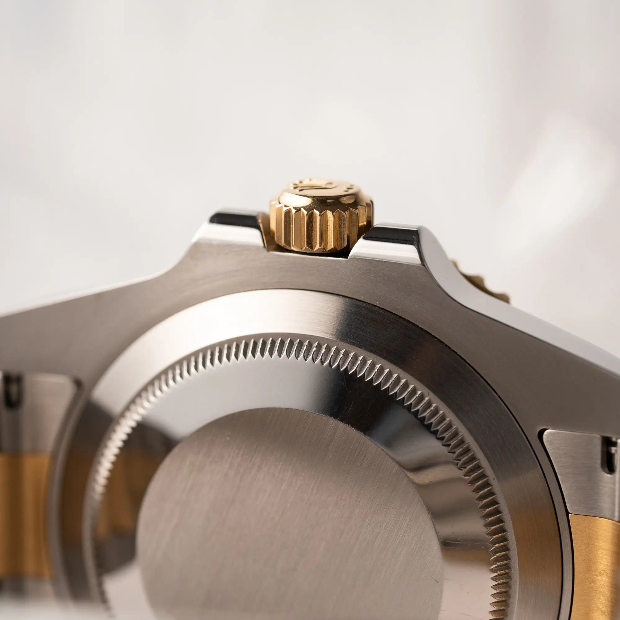 Detailaufnahme des Gehäusebodens und der goldenen Aufzugskrone von der Rolex Submariner Date der Referenz 116613LB in Stahl-Gold mit blauem Zifferblatt - auch mit Nickname Bluesy bennant - am passenden Oytser-Armband in Stahl-Gold