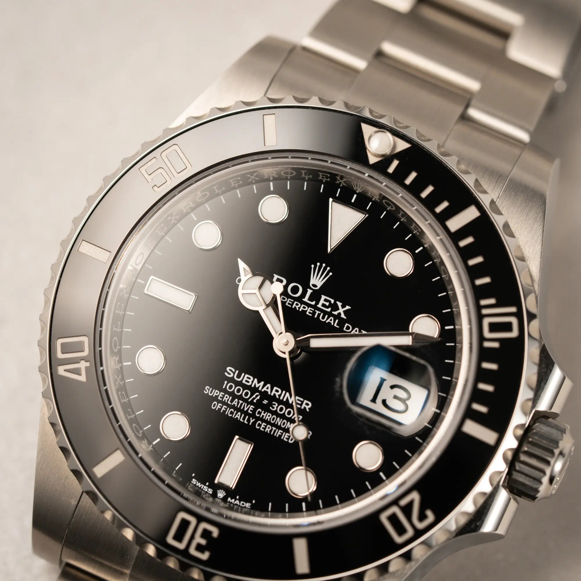 Makroaufnahme der Rolex Submariner Date in schwarz mit Keramik-Lünette am Oyster-Stahlband aus 2023 mit dem 41mm-Oyster-Gehäuse mit Fokus auf dem Zeigersatz