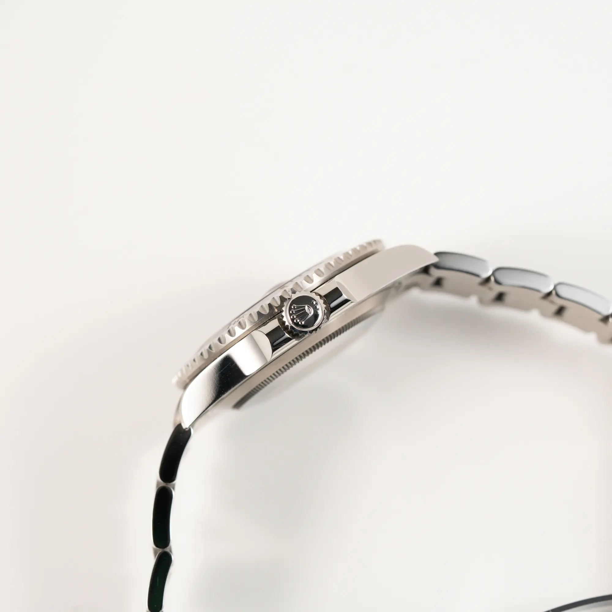 Blick auf die seitliche Gehäuseflanke mit Aufzugskrone der Rolex Submariner Date in schwarz mit Keramik-Lünette am Oyster-Stahlband aus 2023 mit dem 41mm-Oyster-Gehäuse