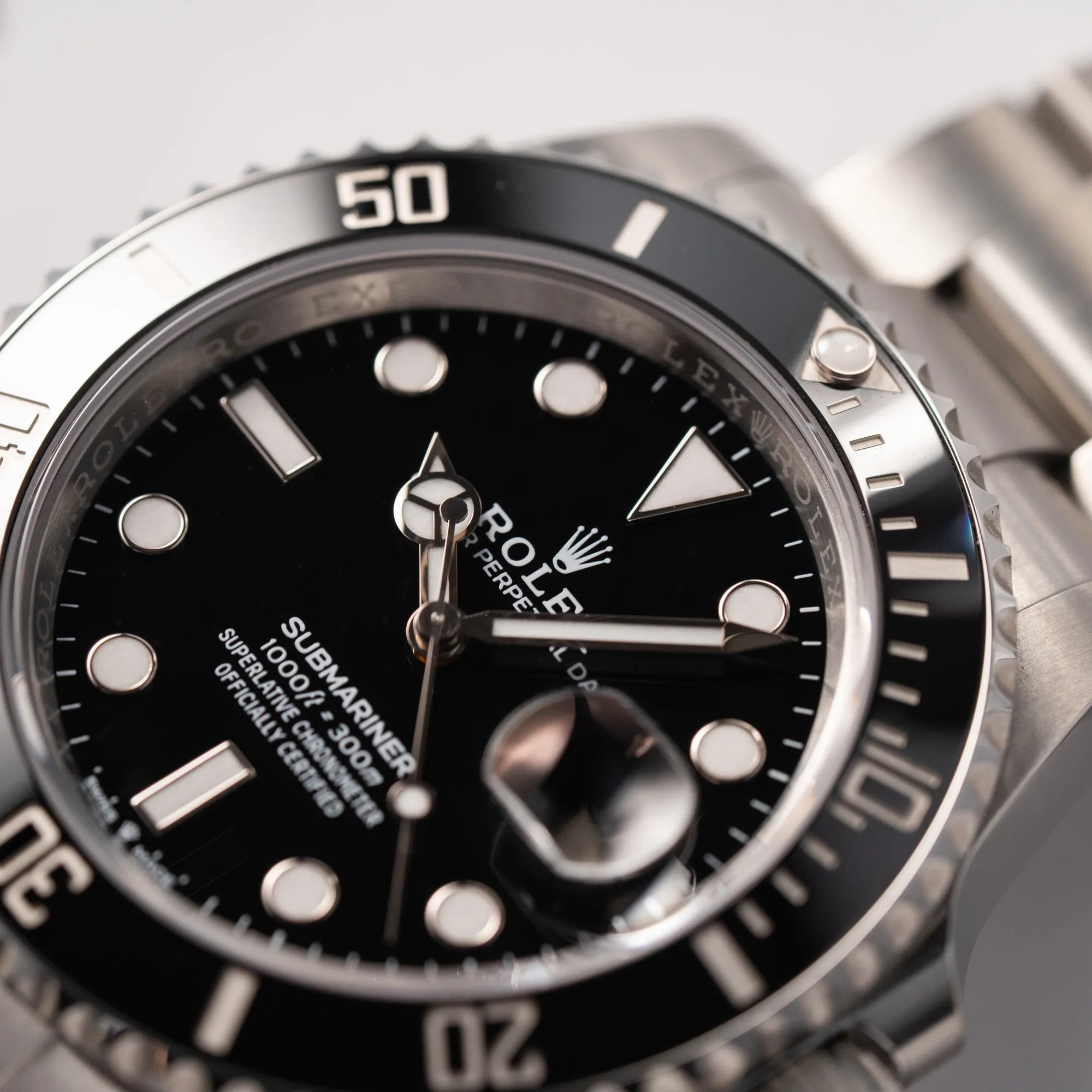 Detailaufnahme der Rolex Submariner Date 126610LN am Oyster-Stahlband im Neuzustand aus 2024 mit Fokus auf dem Zeigersatz