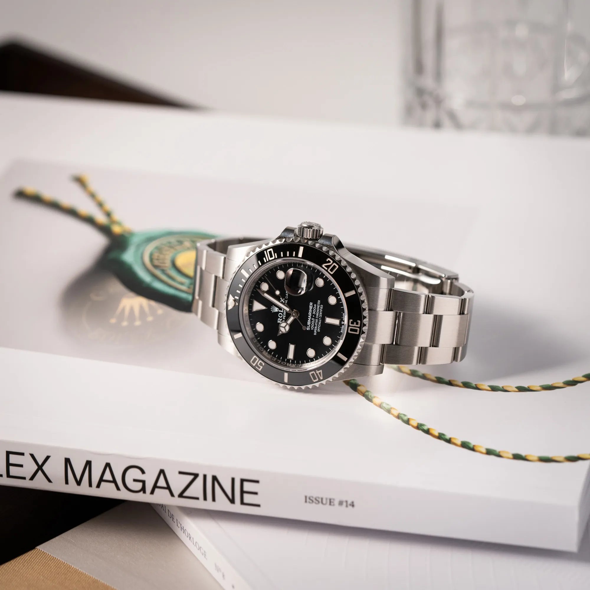 Rolex Submariner Date 126610LN am Oyster-Stahlband im Neuzustand aus 2024 liegt auf einem Rolex Magazin