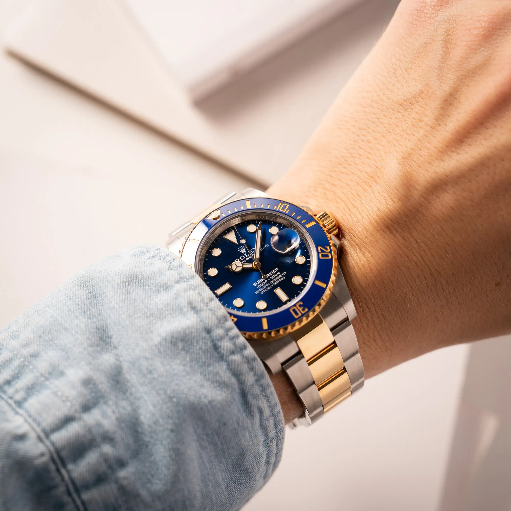 Mann trägt die Rolex Submariner Date 126613LB Bluesy mit der typischen Kombination aus blauem Zifferblatt und Lünette mit dem Gehäuse und Armband aus Stahl-Gold an seinem Handgelenk