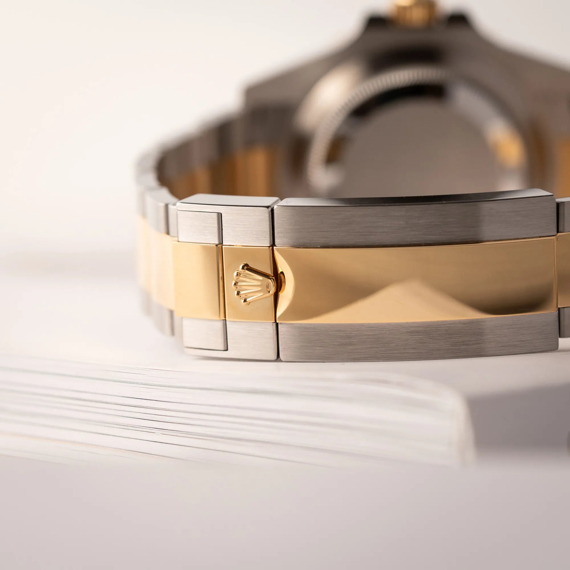 Detailaufnahme der Stahl-goldenen Oyster-Schliesse von der Rolex Submariner Date 126613LB Bluesy mit der typischen Kombination aus blauem Zifferblatt und Lünette mit dem Gehäuse und Armband aus Stahl-Gold