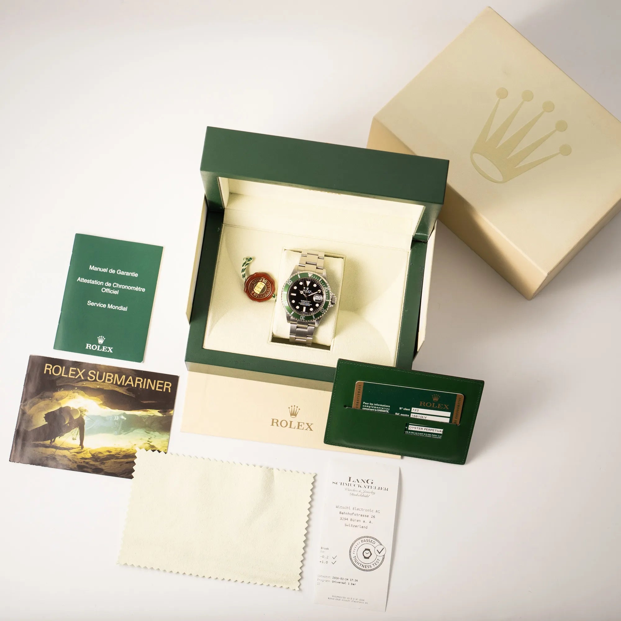 Lieferumfang zugehörig zu der Rolex Submariner Date 16610LV mit der grünen Aluminium-Lünetten-Einlage, bestehend aus Box mit Umkarton, Hangtag, Booklets und originaler Garantiekate