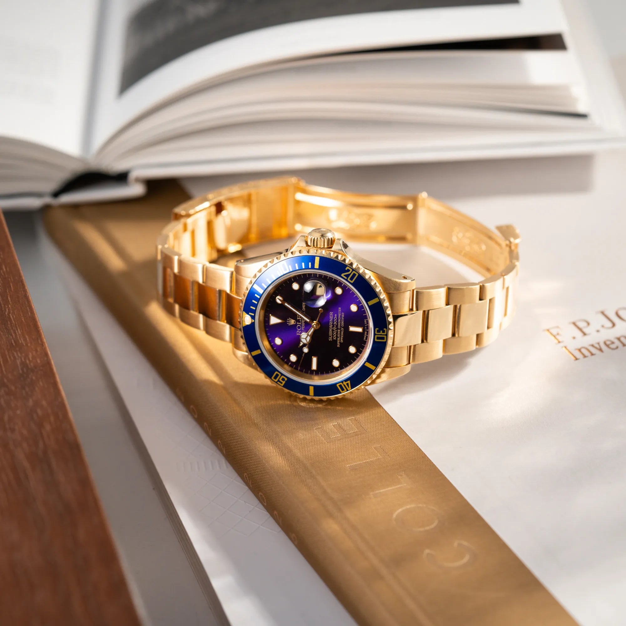 Produktfotografie der Rolex Submariner Date 16618 aus 18Karat Gelbgold mit blauer Lünetten-Einlage und einem sich von BLAU zu LILA verfärbtem Purple-Zifferblatt