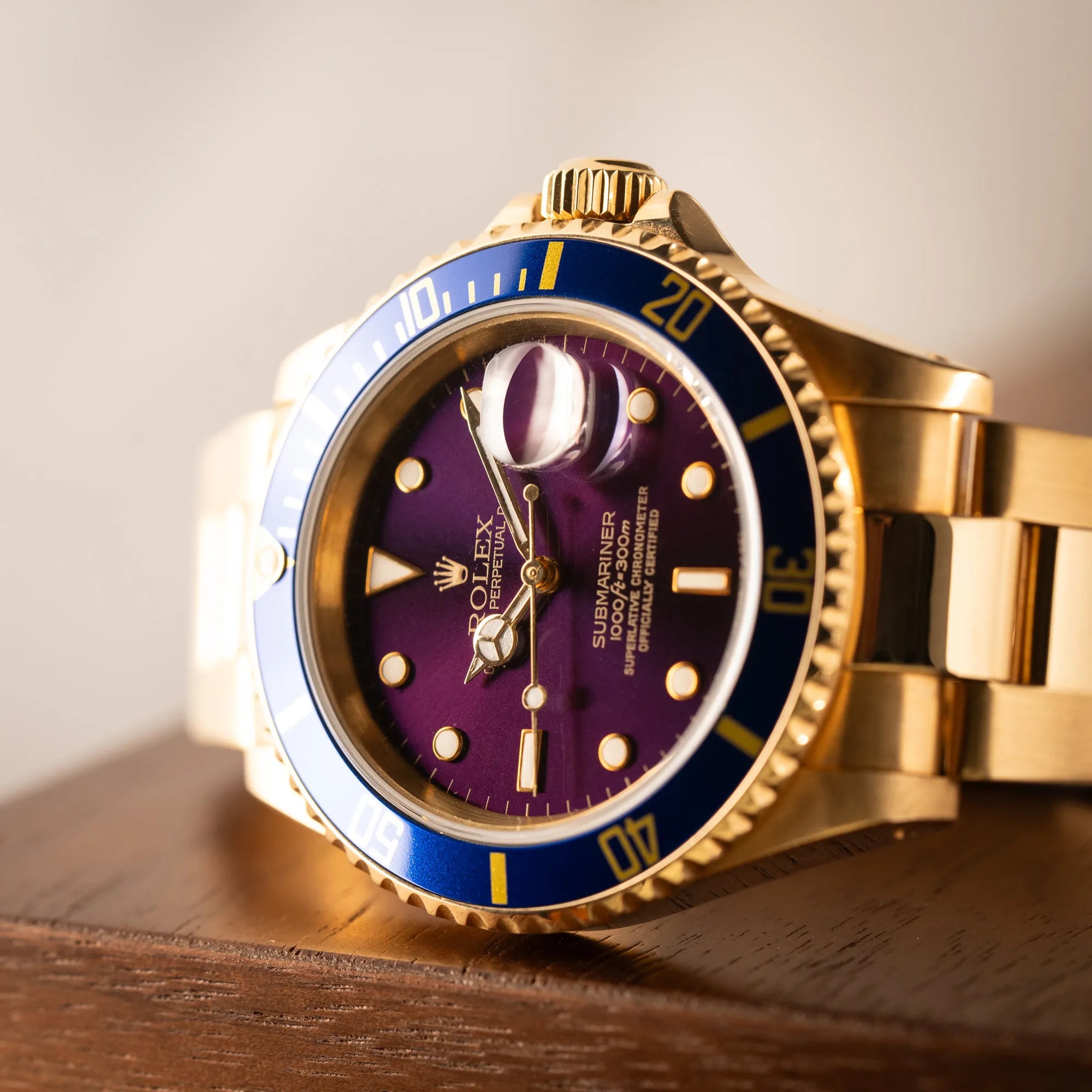 Dteailaufnahme der Rolex Submariner Date 16618 aus 18Karat Gelbgold mit blauer Lünetten-Einlage und einem sich von BLAU zu LILA verfärbtem Purple-Zifferblatt
