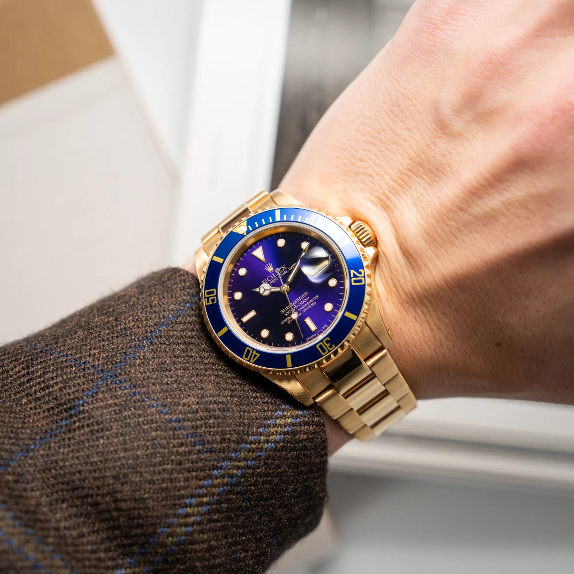 Wristshot mit der Rolex Submariner Date 16618 aus 18Karat Gelbgold mit blauer Lünetten-Einlage und einem sich von BLAU zu LILA verfärbtem Purple-Zifferblatt