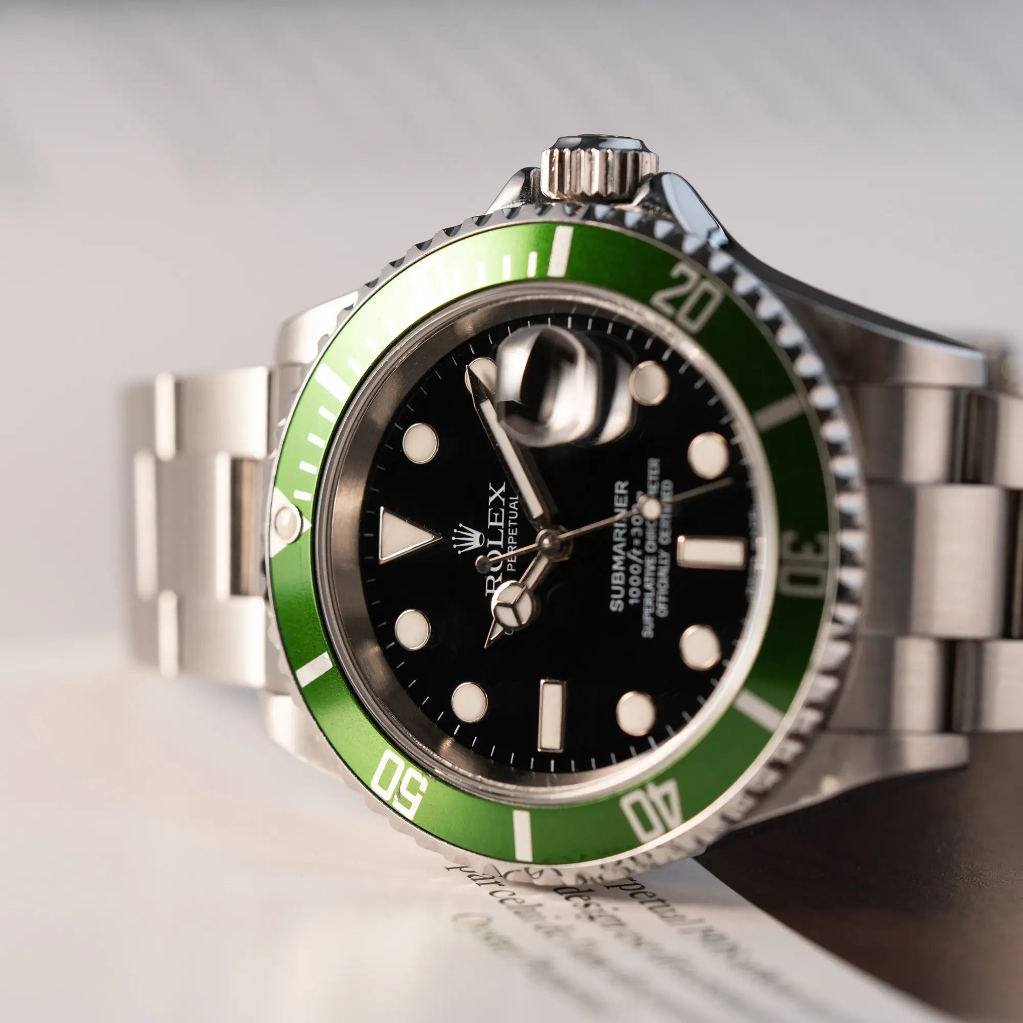Detailaufnahme der Rolex Submariner Date 16610LV "Kermit" mit der schwarzem Zifferblatt und der grünen Aluminium-Lünette