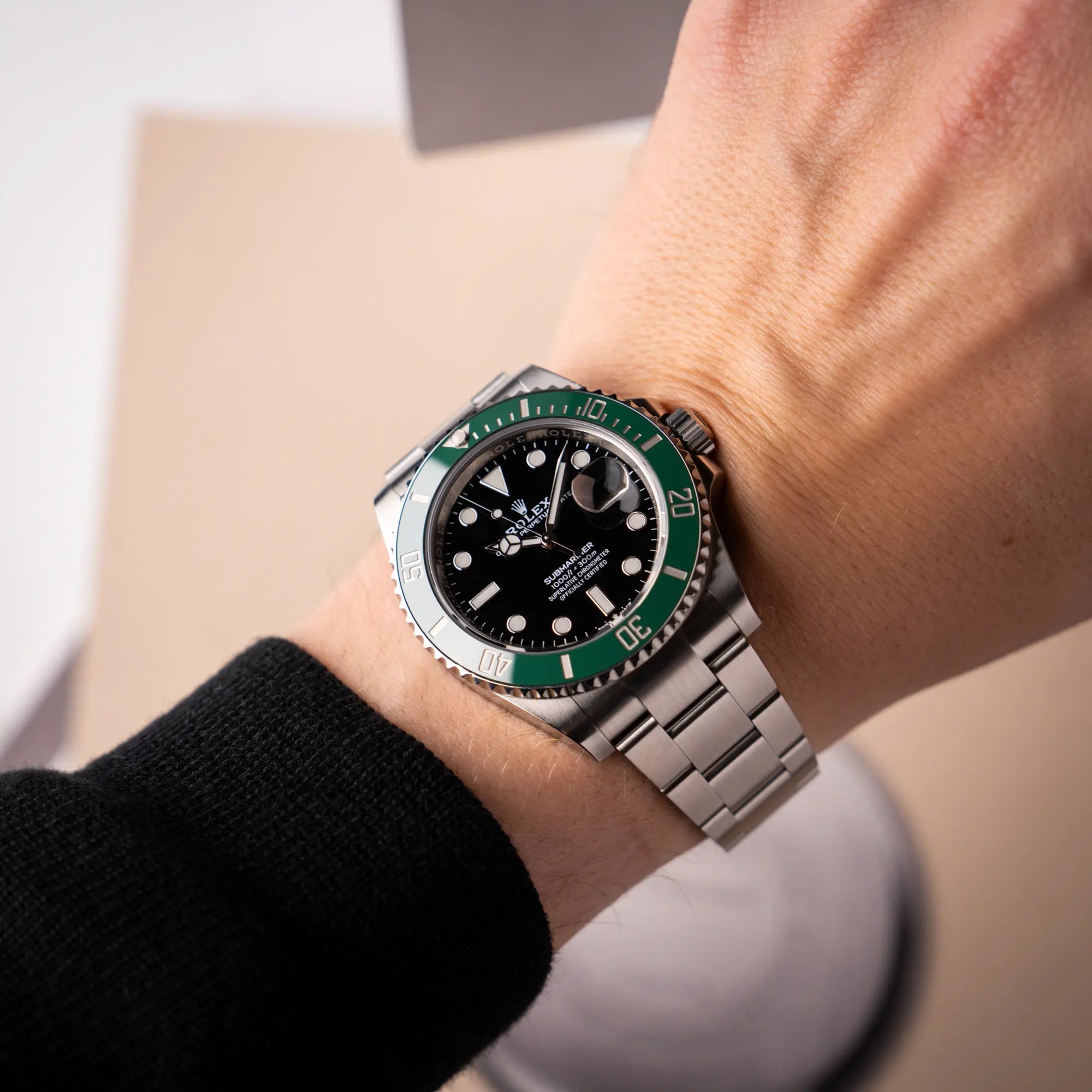 Mann trägt die Rolex Submariner Date Starbucks 126610LV mit schwarzem Zifferblatt und grüner Cerachrom-Lünette an seinem Handgelenk