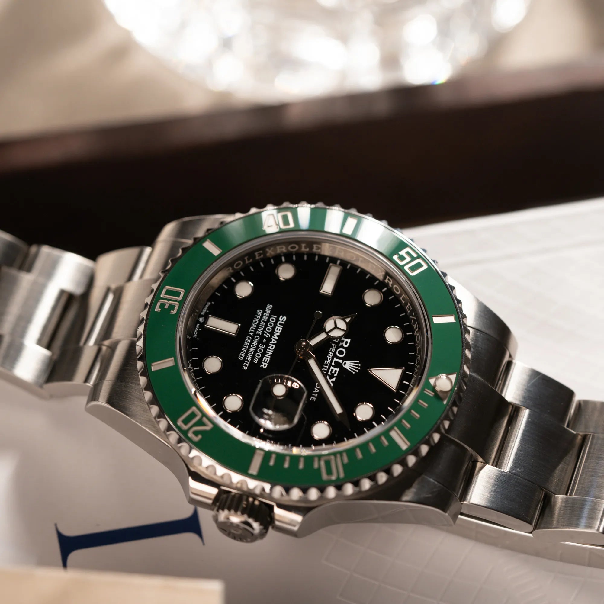 Produktfotografie der Rolex Submariner Date Starbucks 126610LV mit schwarzem Zifferblatt und grüner Cerachrom-Lünette zeigt die Bandanstöße