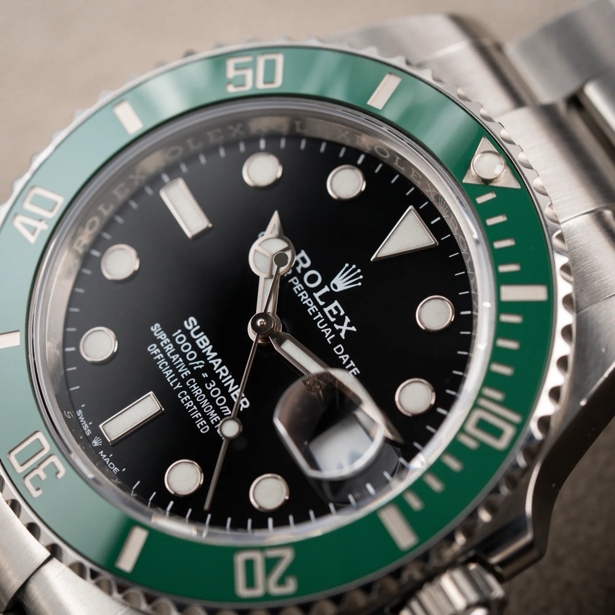 Detailaufnahme des Uhrenkopfs der Rolex Submariner Date Starbucks 126610LV mit schwarzem Zifferblatt und grüner Cerachrom-Lünette