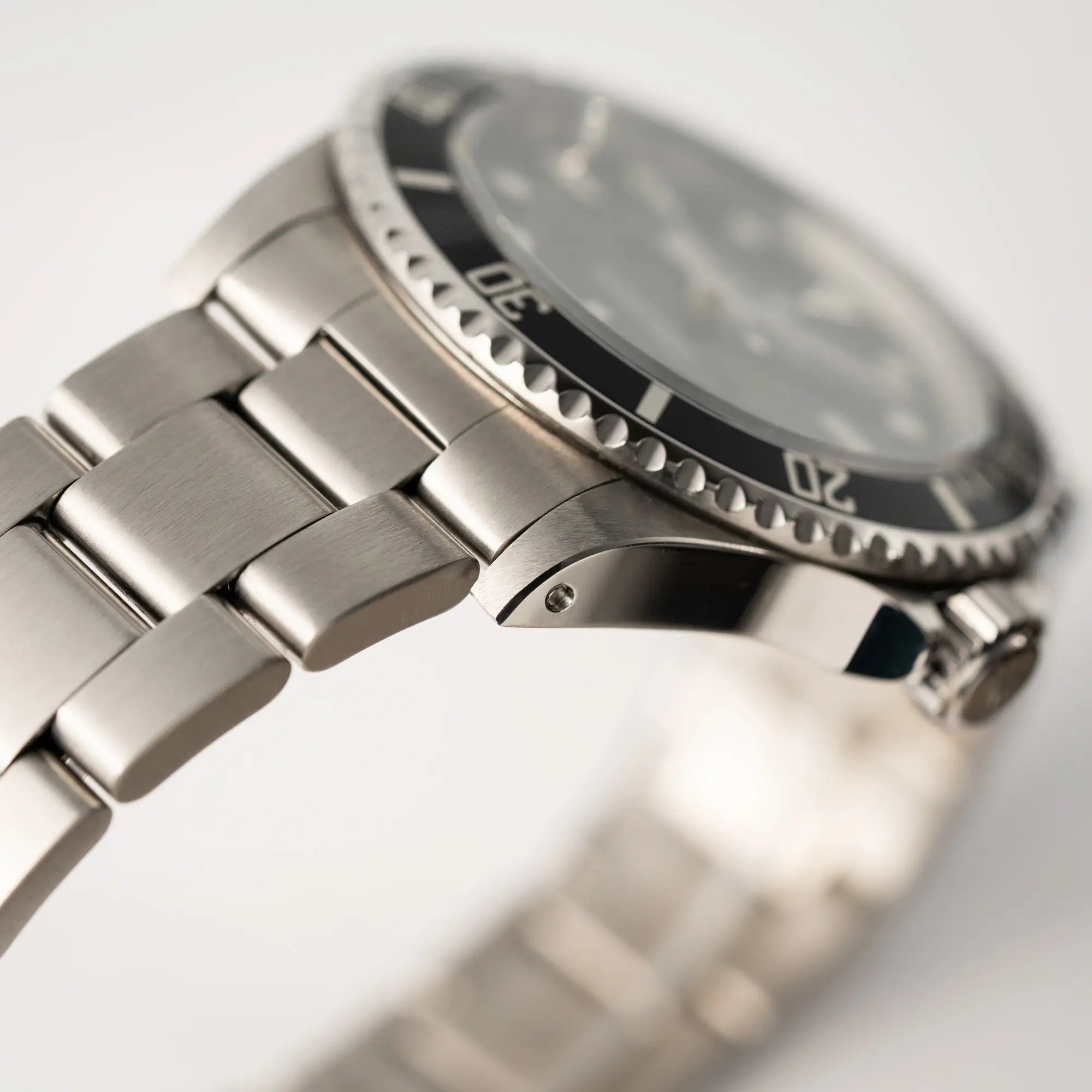 Produktfotografie der Rolex Submariner No Date 14060M mit schwarzem Zifferblatt und der klassischen schwarzen Aluminium-Lünette zeigt den super Zustand mit scharfkantigen Bandanstößen