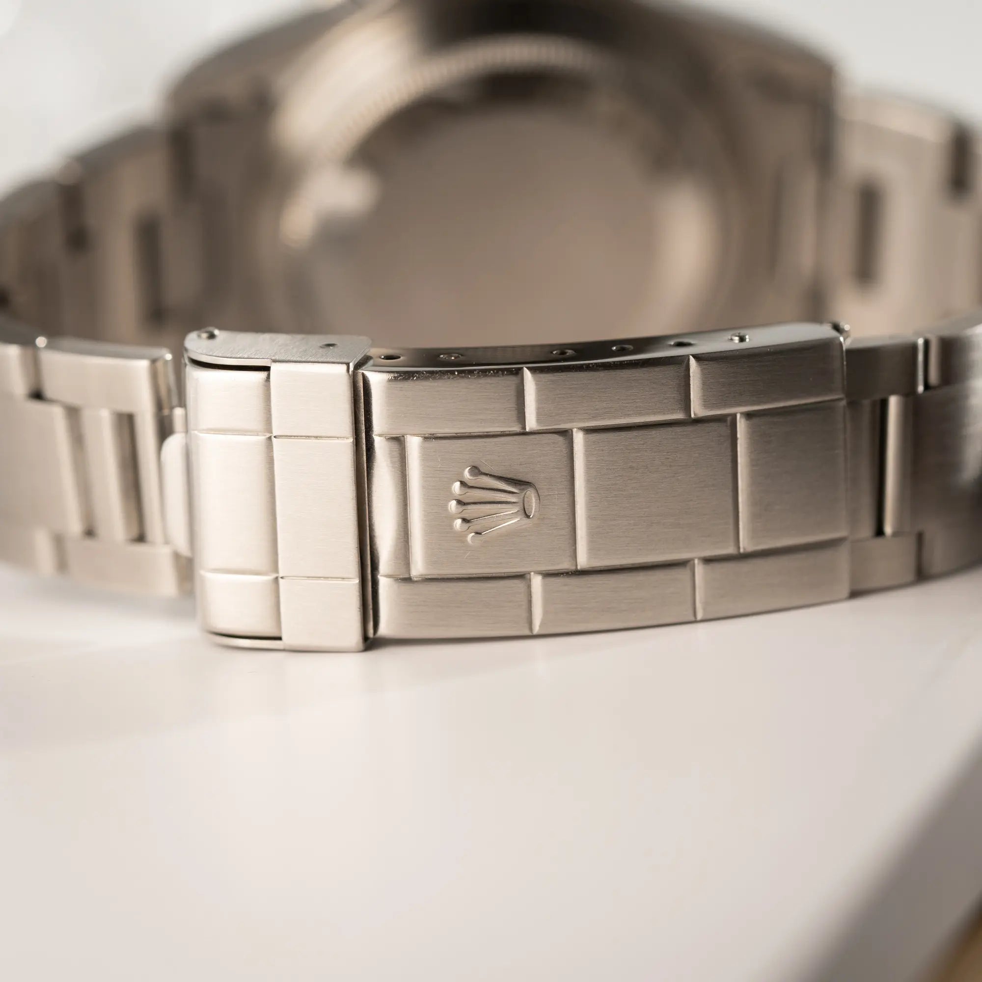 Detailaufnahme der Oyster-Stah-Faltschliesse mit Rolex-Logo von der Rolex Submariner No Date 14060M mit schwarzem Zifferblatt und der klassischen schwarzen Aluminium-Lünette