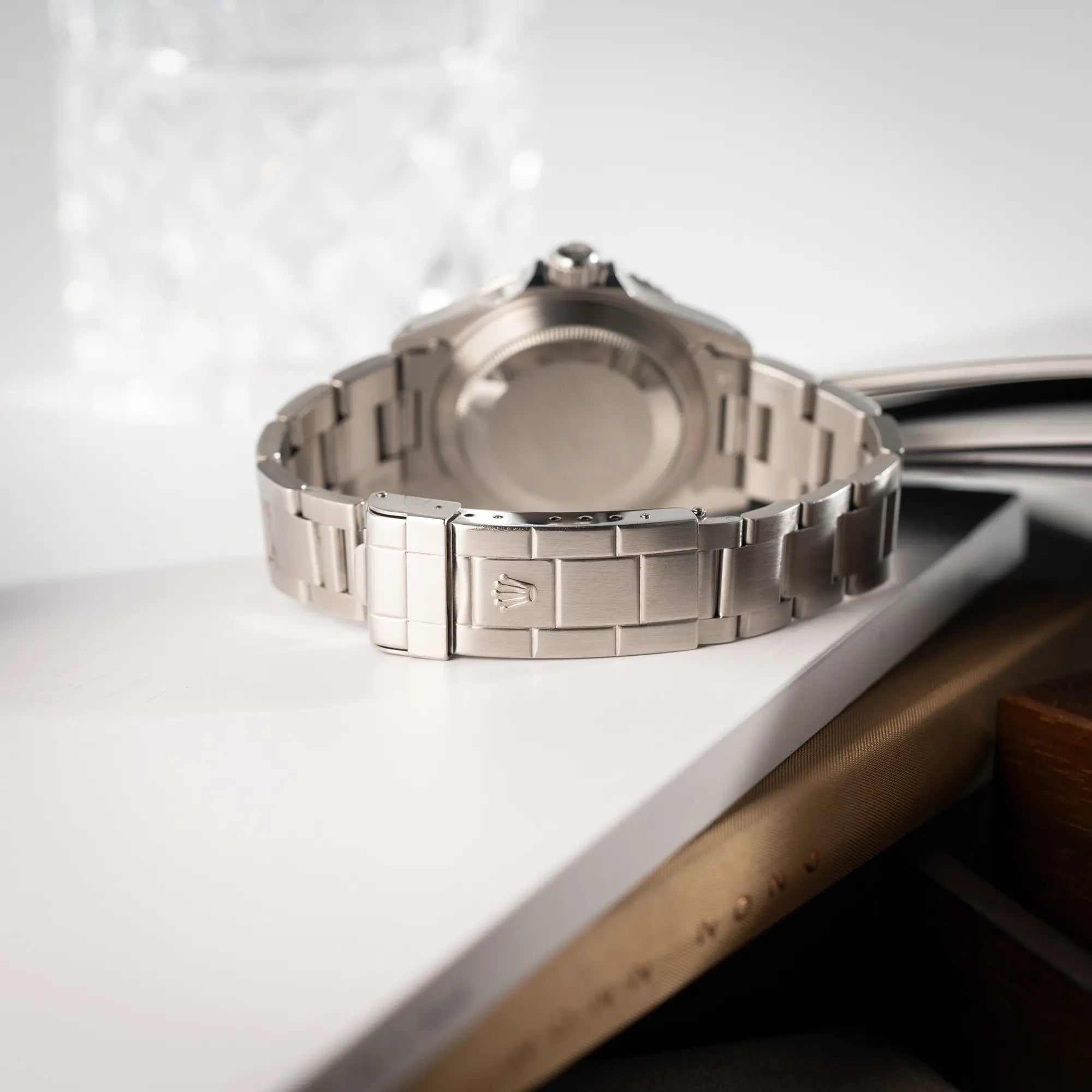 Produktfotografie der Rolex Submariner No Date 14060M mit schwarzem Zifferblatt und der klassischen schwarzen Aluminium-Lünette zeigt das Oyster-Stahlband mit Faltschliesse