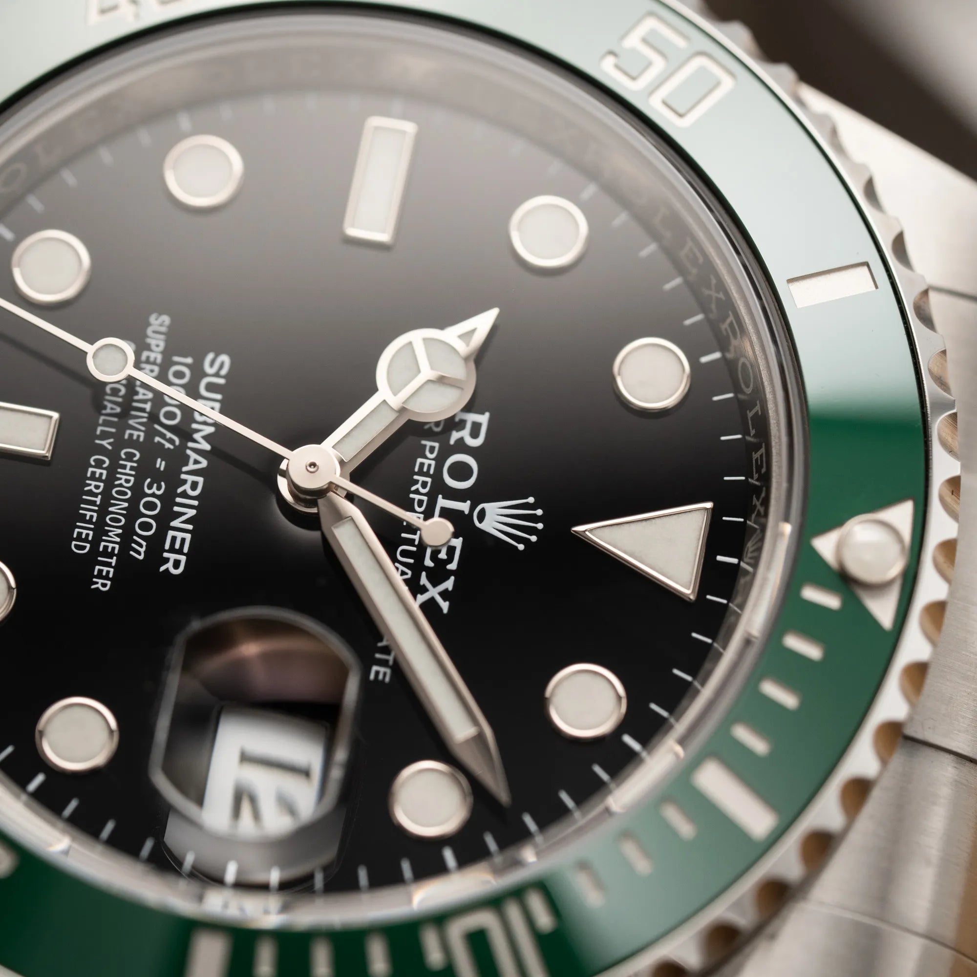 Detailaufnahme der Rolex Submariner Date "Starbucks" der Referenz 126610LV mit der modelltypischen grünen Keramik-Lünette, die im Kontrast zu dem schwarzen Zifferblatt steht