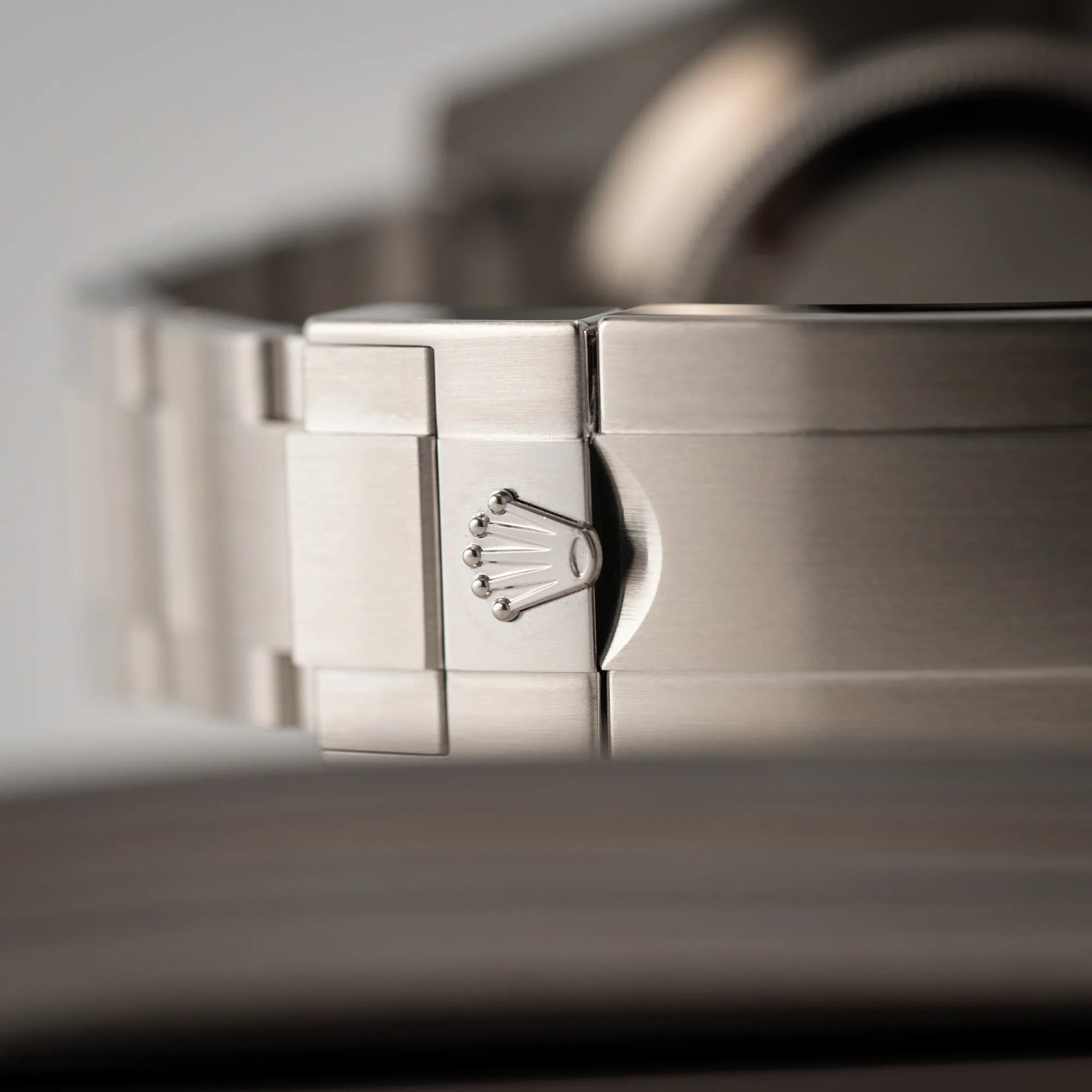 Detailaufnahme der Rolex-Krone auf der Oyster-Stahl-Faltschliesse der Rolex Submariner 114060 No Date aus 2019 in der klassischen schwarzen Ausführung im Neuzustand