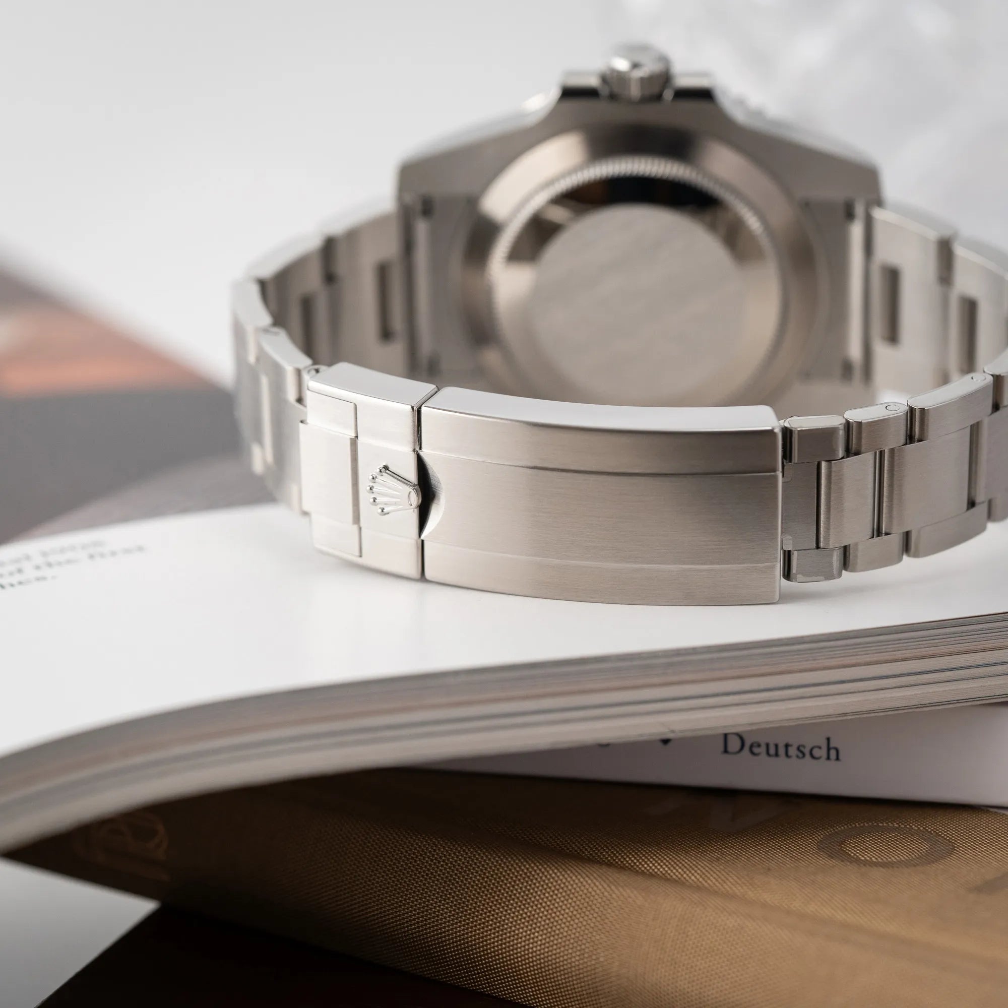 Produktfotografie der Rolex Submariner 114060 No Date aus 2019 in der klassischen schwarzen Ausführung im Neuzustand zeigt die Oyster-Stahl-Faltschliesse am Oyster-Stahl-Band