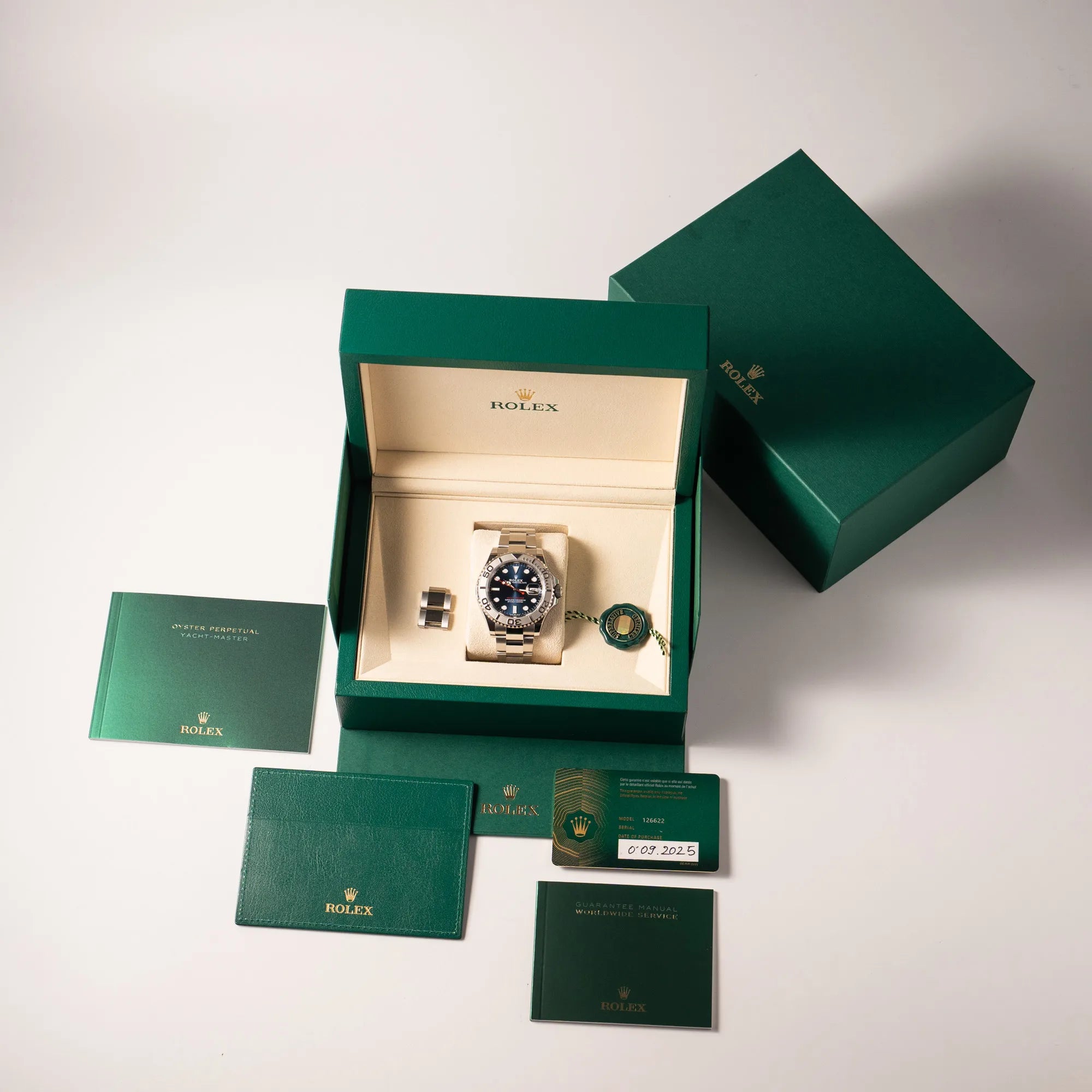 Lieferumfang zu der Rolex Yacht-Master 40 der Referenz 126622 mit der Platin-Lünette in der blauen Zifferblatt-Variant, bestehend aus Box mit Umkarton, Hangtag, originaler Garantiekarte und allen Booklets