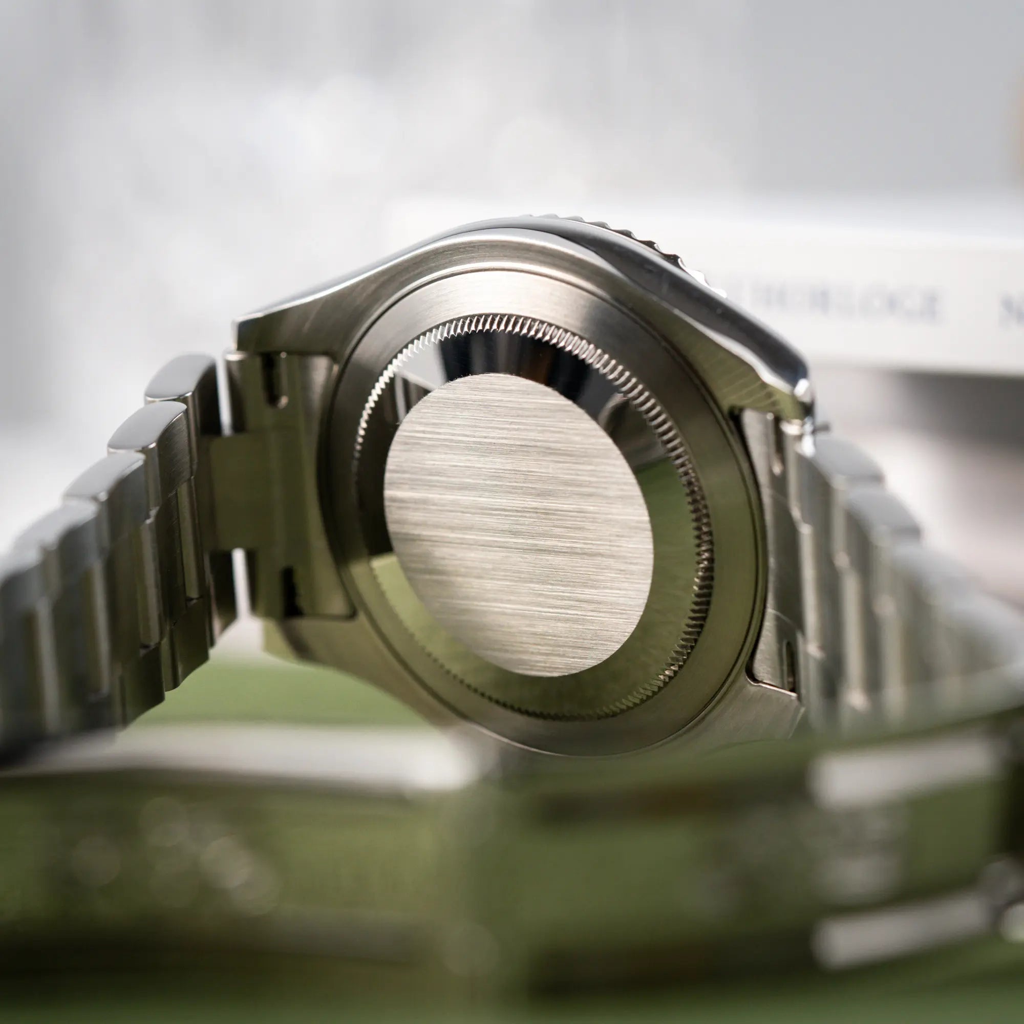 Produktfotografie der Rolex Yacht-Master 40 Rolesium der Referenz 16622 mit dem silberfarbenen Platin-Zifferblatt und Platin-Lünette zeigt den Gehäuseboden der Armbanduhr