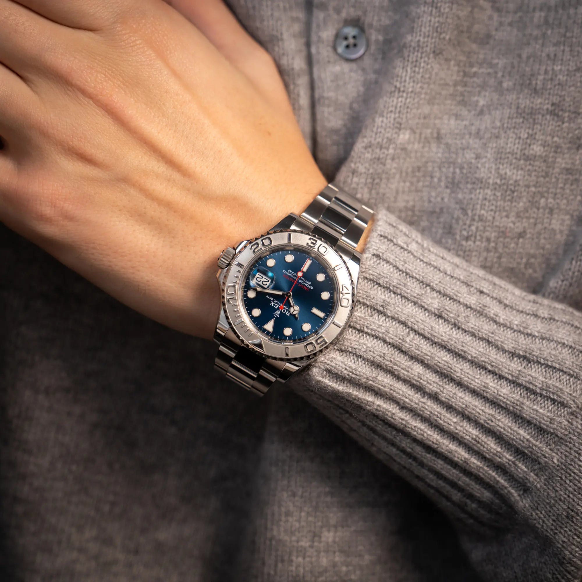 Mann hat die Rolex Yachtmaster 40 der Referenz 126622 mit blauem Zifferblatt und der Rolesium-Lünette aus Platin an seinem Handgelenk
