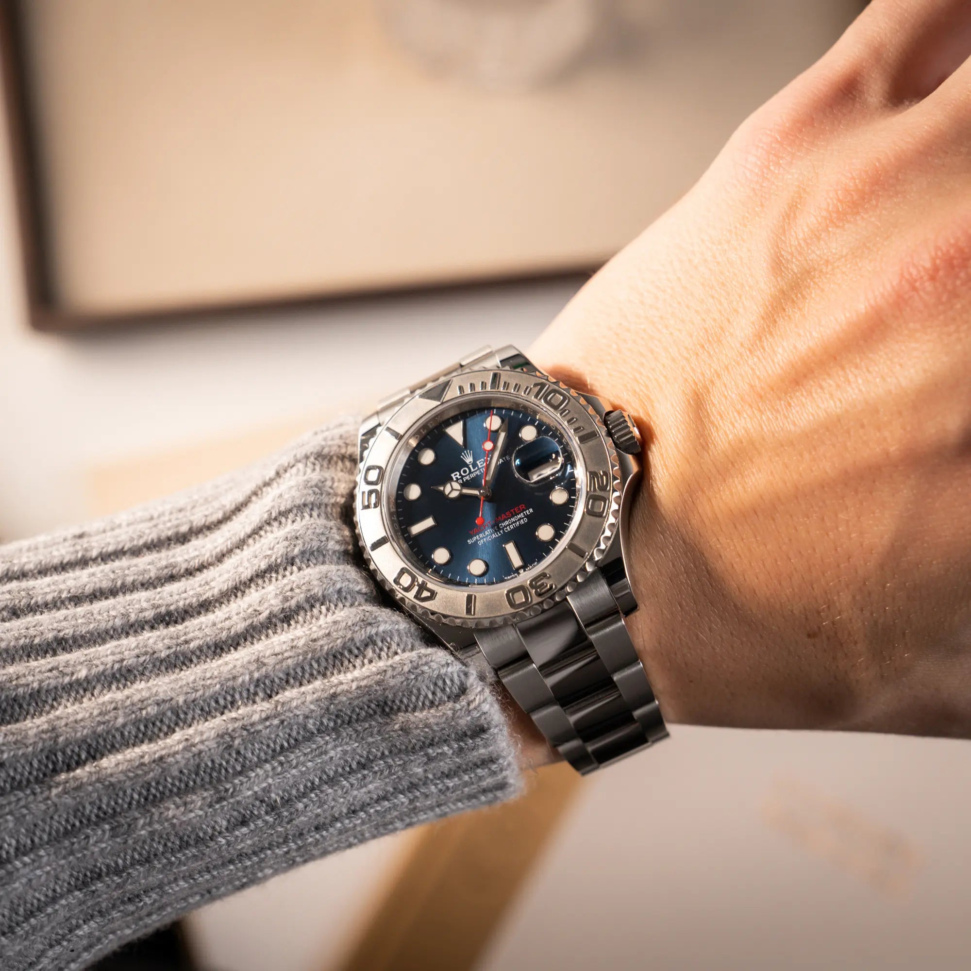 Mann trägt die Rolex Yachtmaster 40 der Referenz 126622 mit blauem Zifferblatt und der Rolesium-Lünette aus Platin für einen Wristshot an seinem Handgelenk