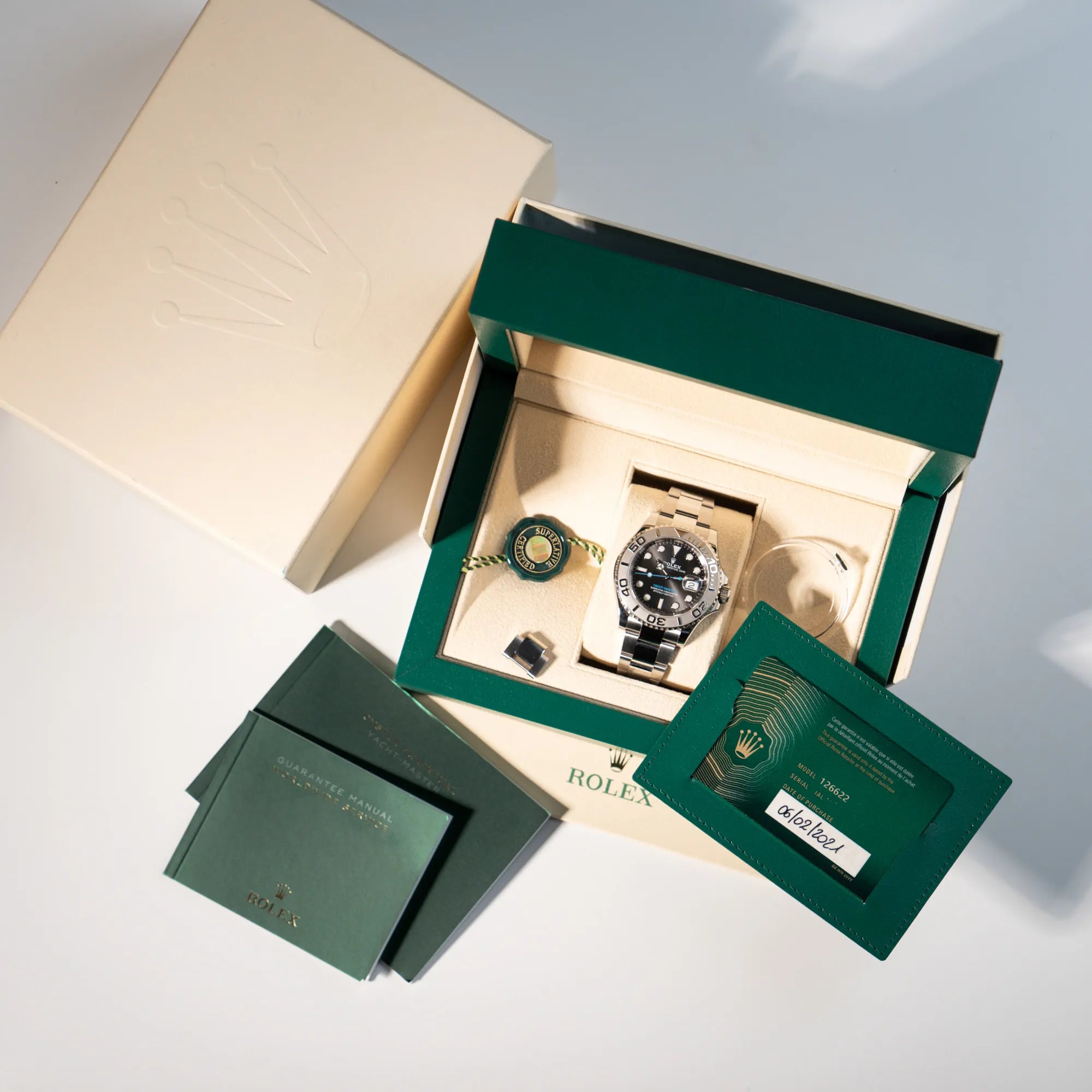 Lieferumfang zu der der Rolex Yachtmaster 40 mit Platin-Lünette der Referenz 126622 mit dem Rhodium-Zifferblatt und hellblauem Sekundenzeiger, bestehend aus Box, Papieren, Umkarton, Booklets, Hangtag und Lünettenschutz