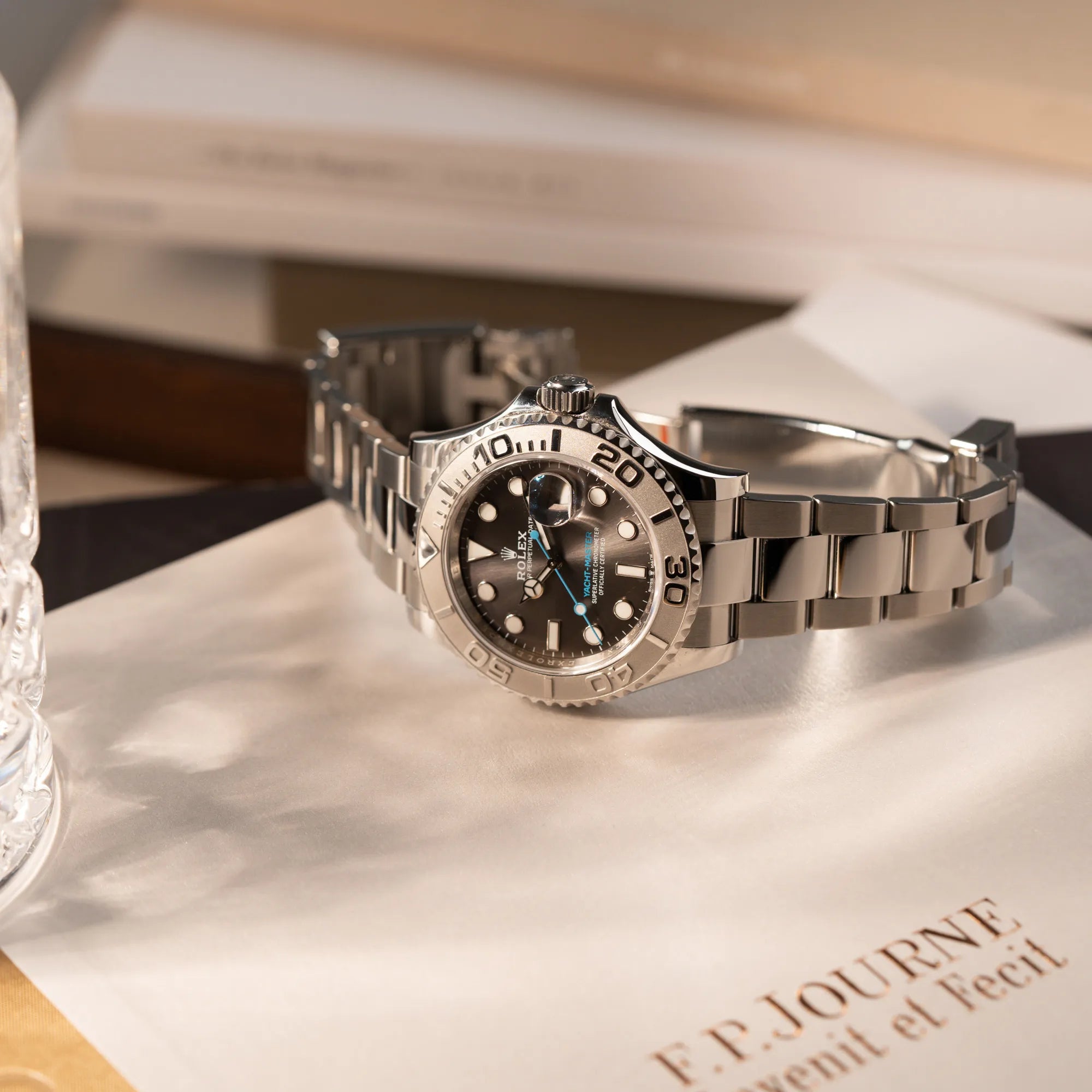 Produktfotografie der Rolex Yachtmaster 40 mit Platin-Lünette der Referenz 126622 mit dem Rhodium-Zifferblatt und hellblauem Sekundenzeiger, während die Uhr auf einem FP Journe Buch liegt
