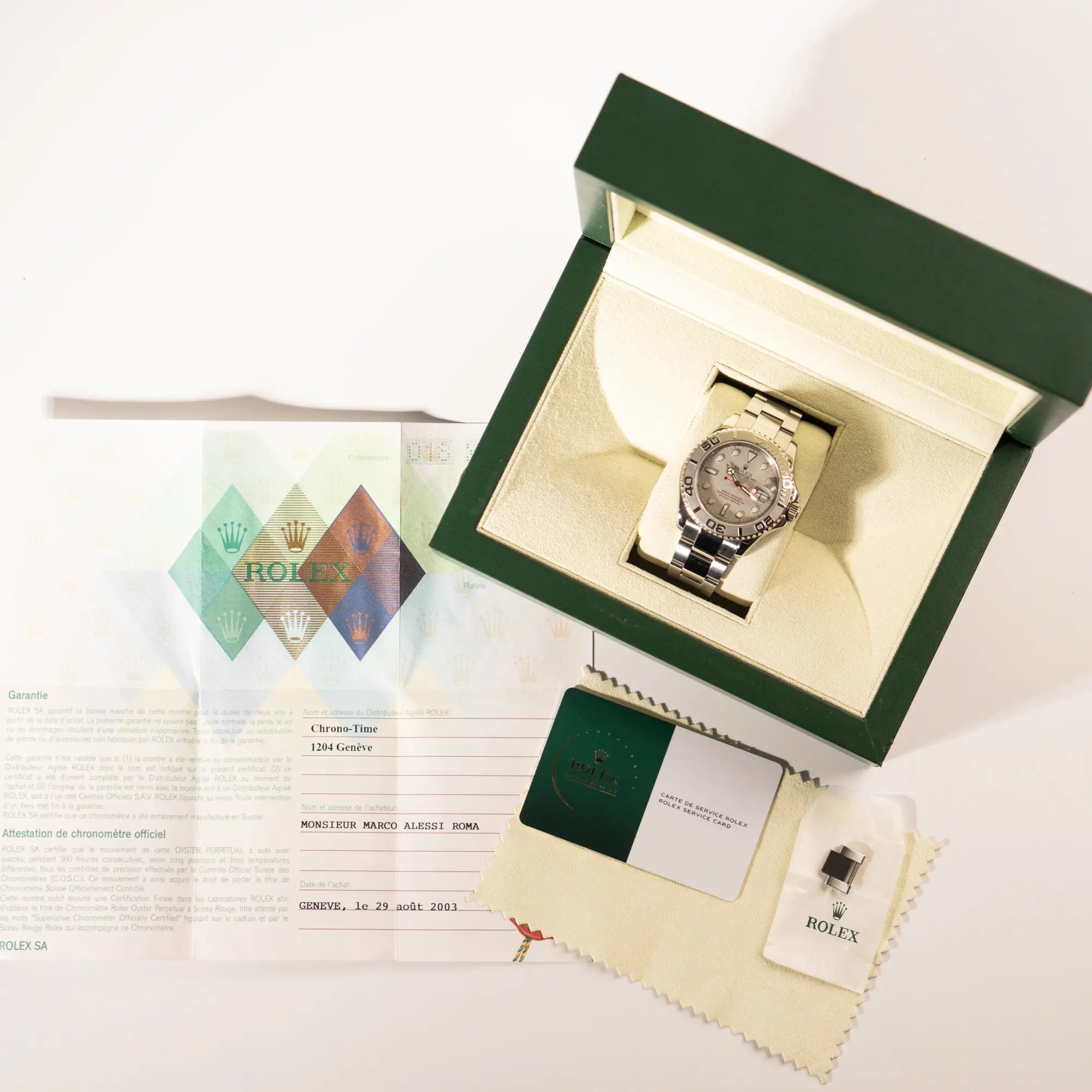 Lieferumfang zu der Rolex Yachtmaster 40 Platinum mit der Referenz 16622 mit Platin-Lünette und dem typischen roten Sekundenzeiger, betsehend aus Box, Poliertuch, Papieren und originaler Rolex-Service-Karte aus 2024