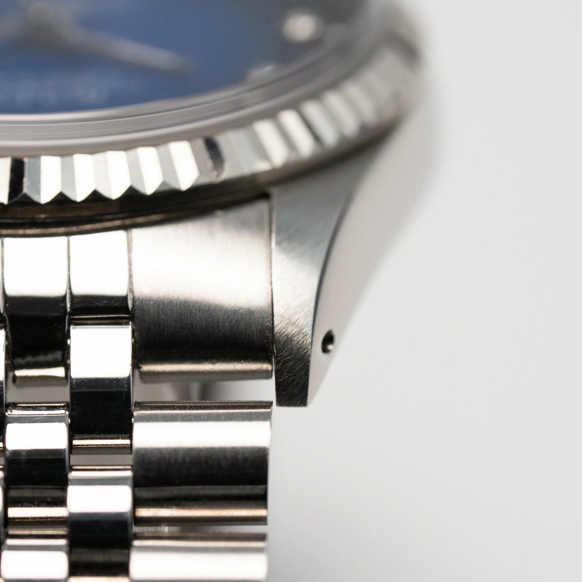 Detailaufnahme der liegenden Rolex Datejust 36 mit einem sehr seltenen Degradé Diamond Zifferblatt, dass von Blau ins Schwarze verläuft, mit Fokus auf den scharfen Kanten des Bandanstoßes