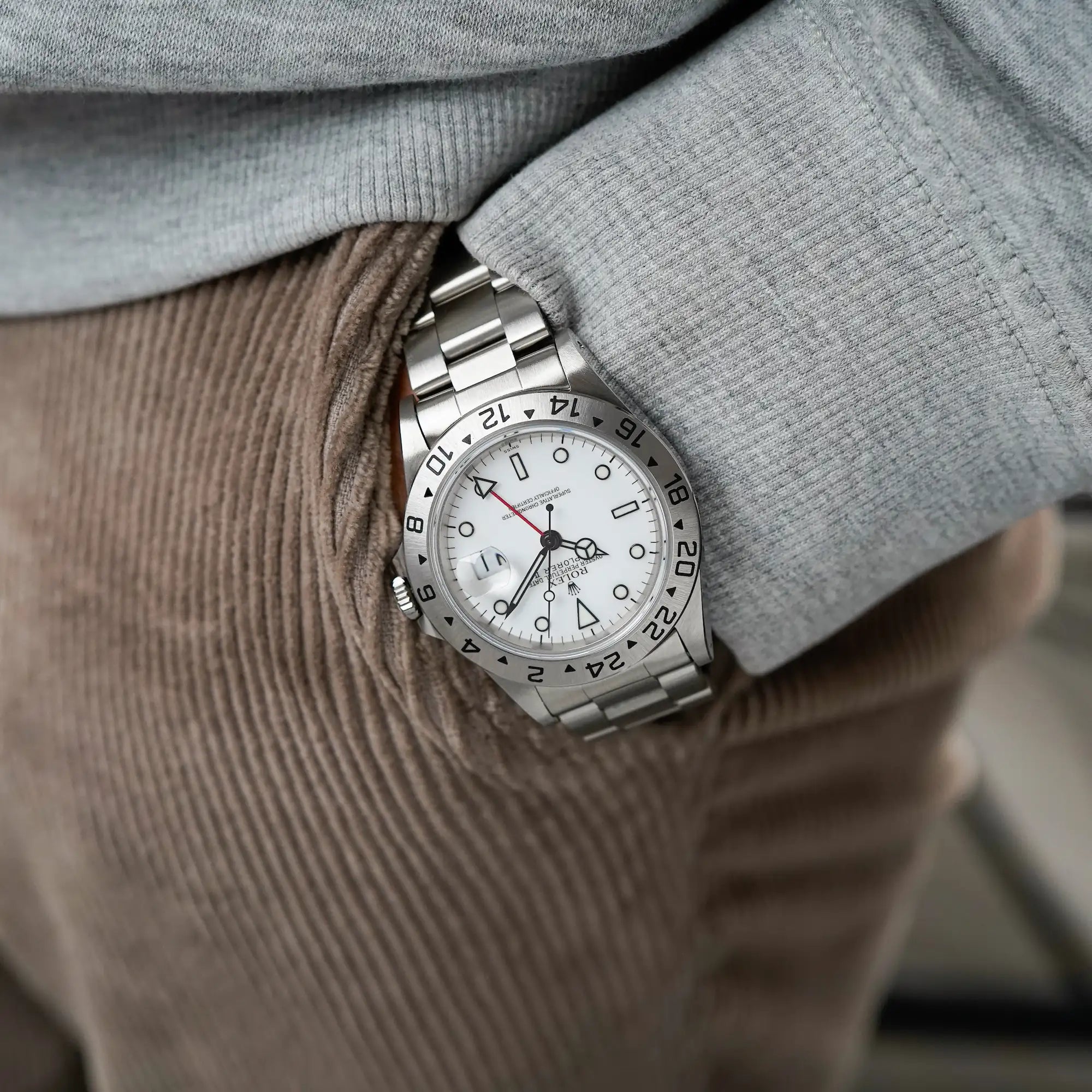 Mann trägt die Rolex Explorer 2 mit einem weißen "Swiss-Only"-Zifferblatt an seinem Handgelenk, während seine Hand in der Hosentasche steckt