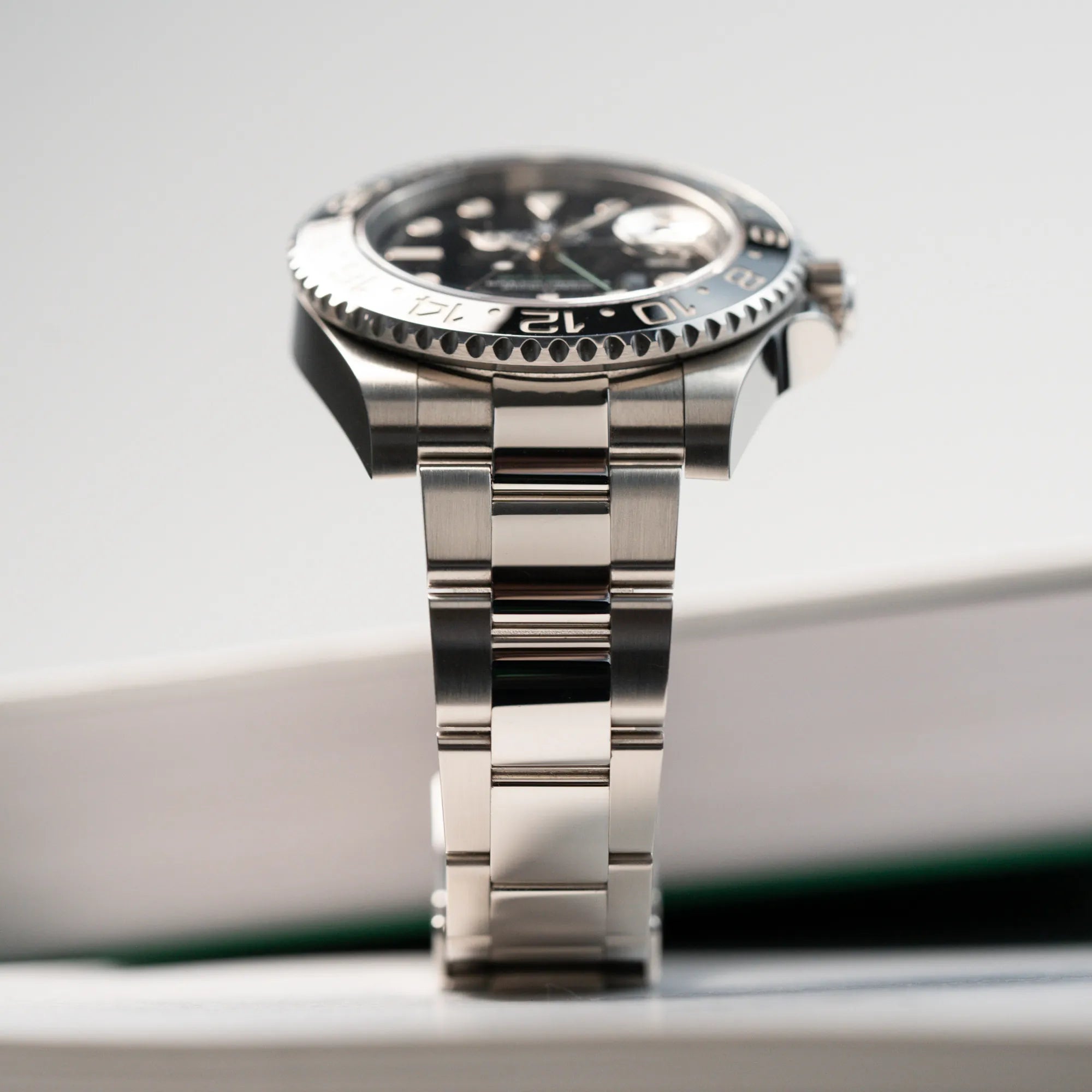 Produktfotografie der Rolex GMT Master 2 in Schwarz mit der Keramik-Lünette mi Fokus auf dem Oyster-Stahlband in einem fast neuen Zustand