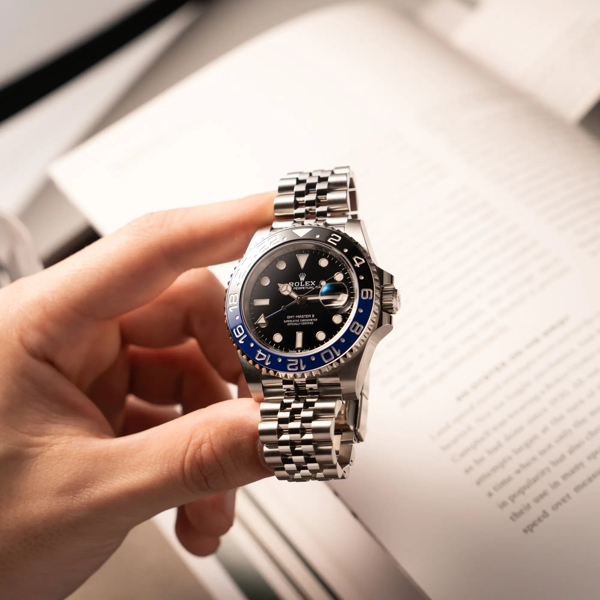 Mann hält die Rolex GMT-Master II Batgirl der Referenz 126710BLNR mit blau schwarzer Lünette am Jubilee-Armband in seiner Hand und präsentiert die Uhr in die Kamera