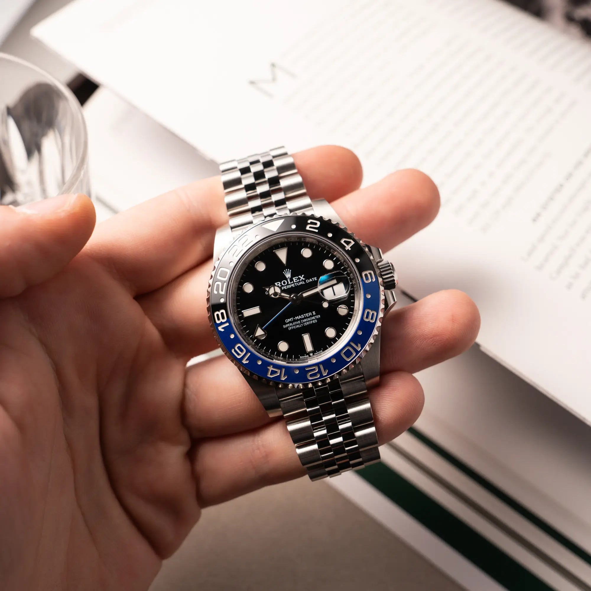 Mann hält die Rolex GMT-Master II Batgirl der Referenz 126710BLNR mit blau schwarzer Lünette am Jubilee-Armband in seiner Hand